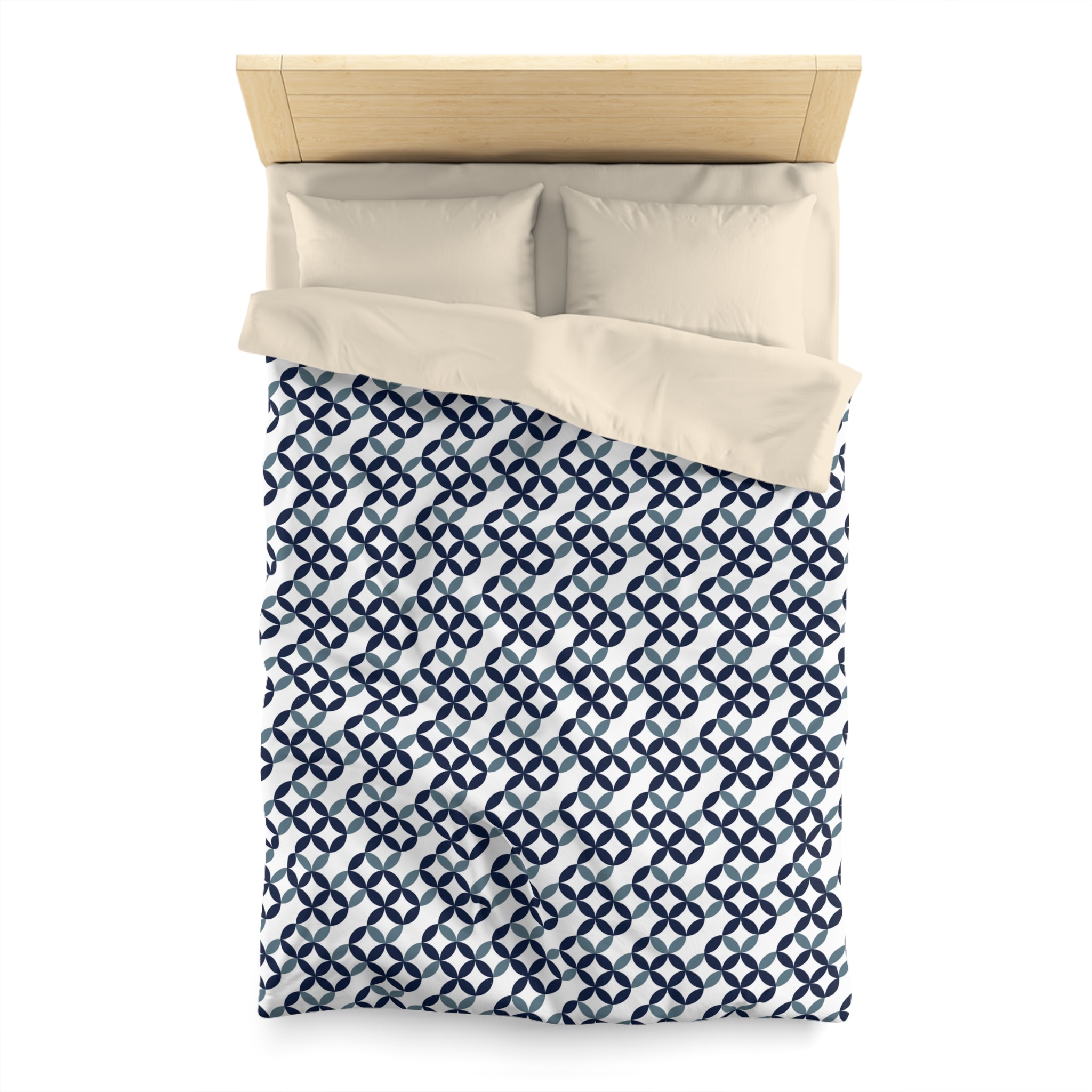 a neatly made bed with a blue and white patterned comforter and two pillows.