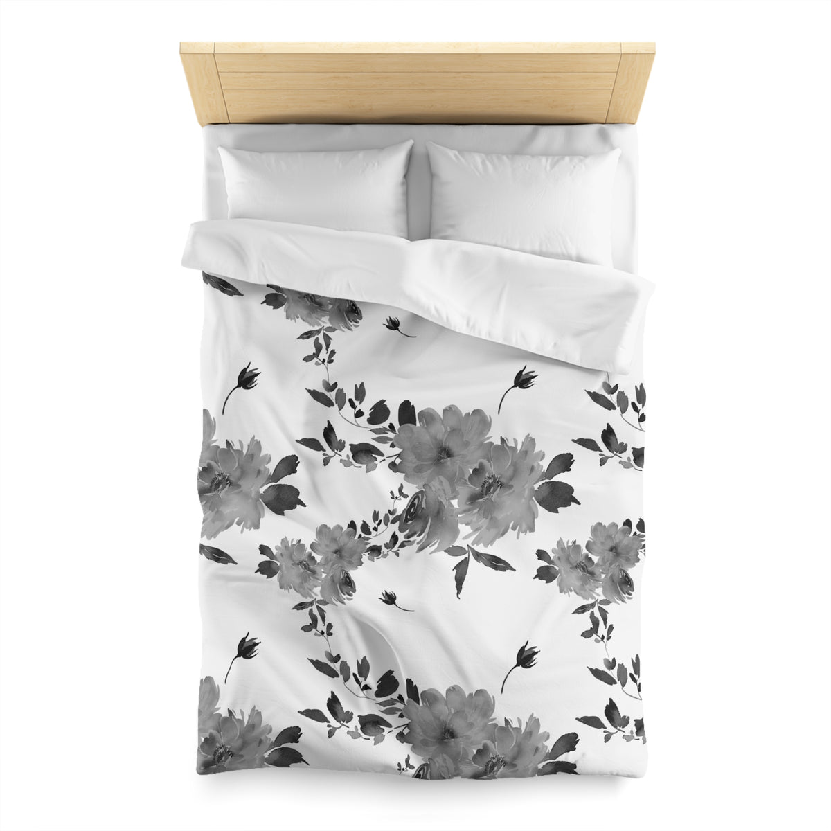 a neatly made bed with a white comforter and a floral pattern on it.