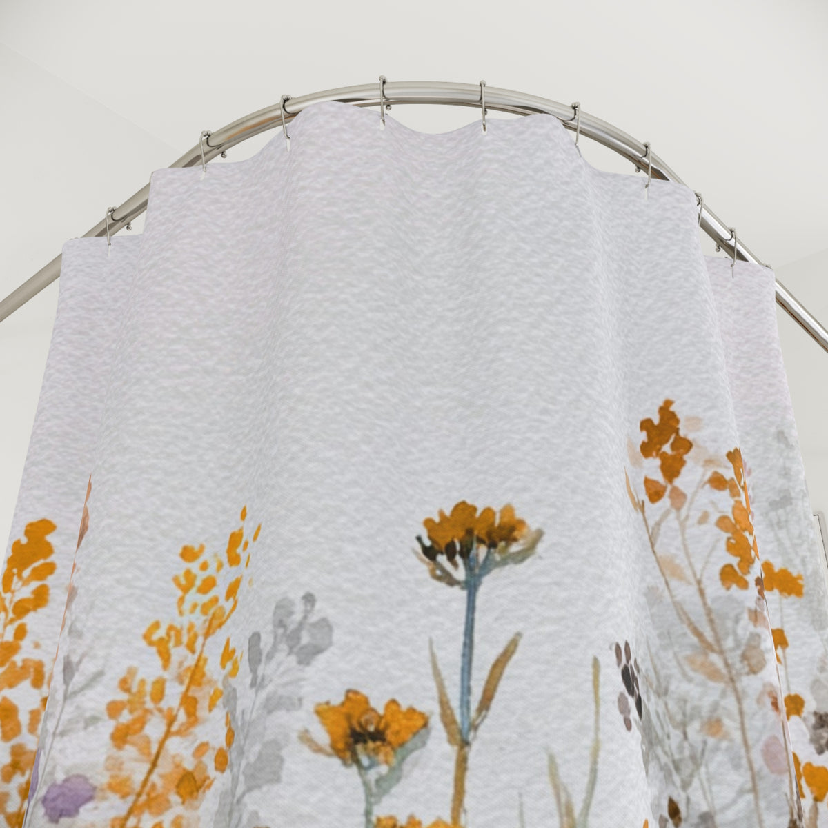 a white shower curtain with a floral pattern, featuring a mix of yellow and orange flowers. The curtain is hanging from a metal rod, and the overall scene appears to be a close-up view of the curtain.