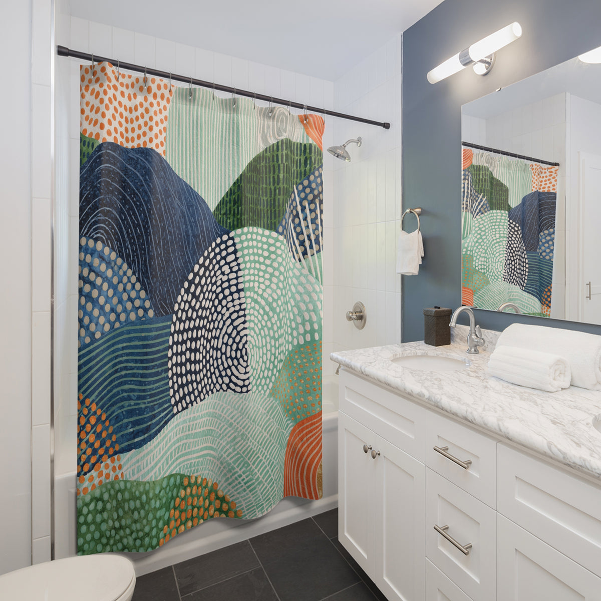 a modern bathroom with a colorful abstract patterned shower curtain, a white vanity with a marble countertop, and a large mirror above the vanity.