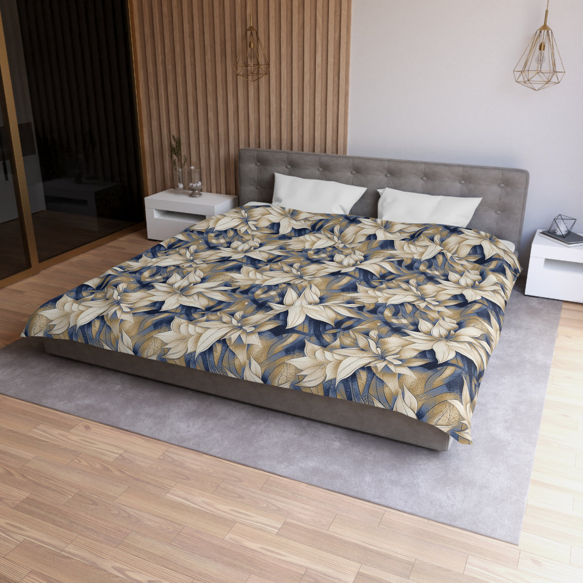 a modern bedroom with a large bed covered in a floral print comforter. The bed is positioned against a wall with a wooden panel. The room has a minimalist design, with a gray headboard and white nightstands. There is a pendant light hanging above the bed, and a vase on one of the nightstands. The overall color scheme of the room is neutral, with the floral print adding a touch of nature and warmth to the space.