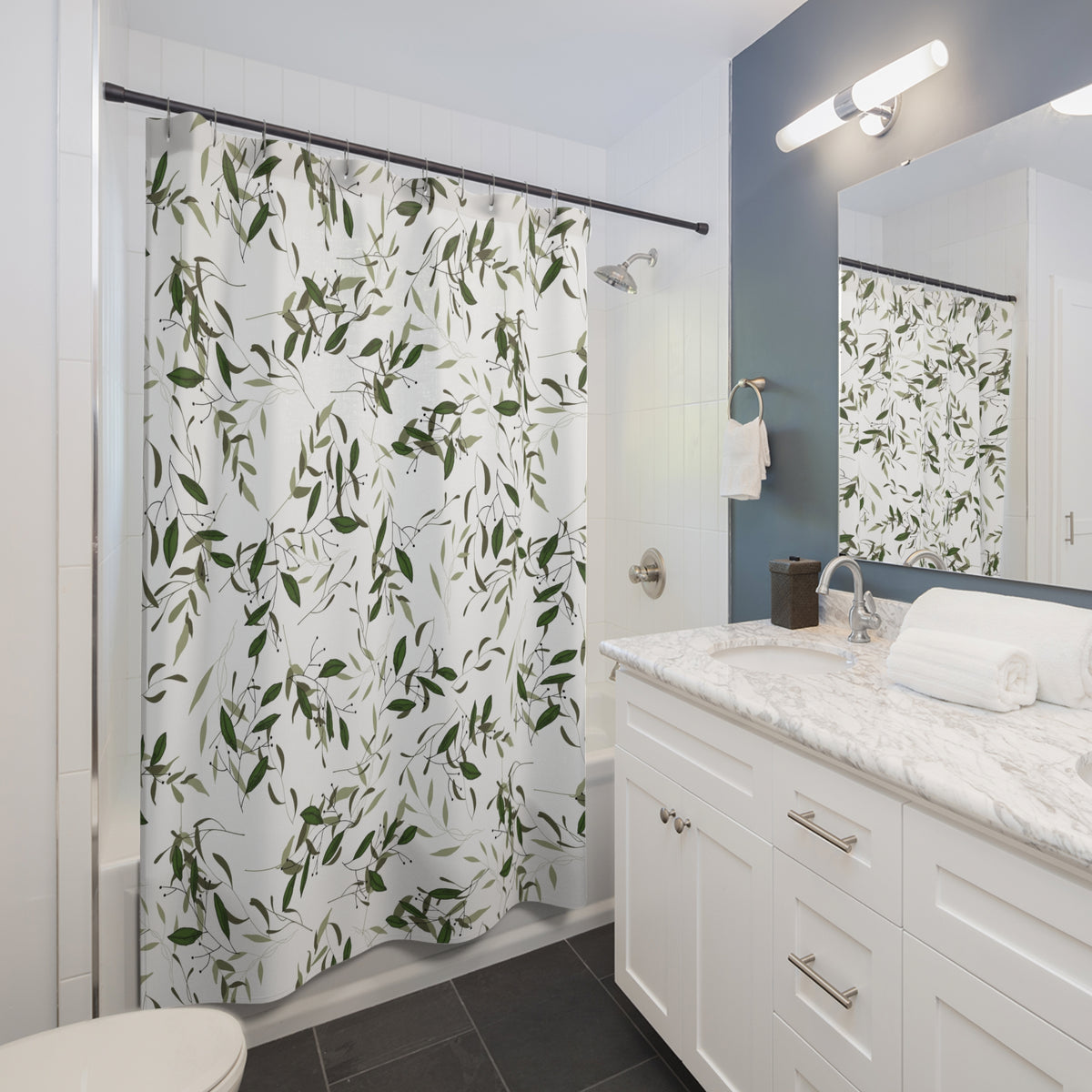 a modern bathroom with a white vanity, a shower curtain with a leafy green pattern, and a mirror above the vanity.