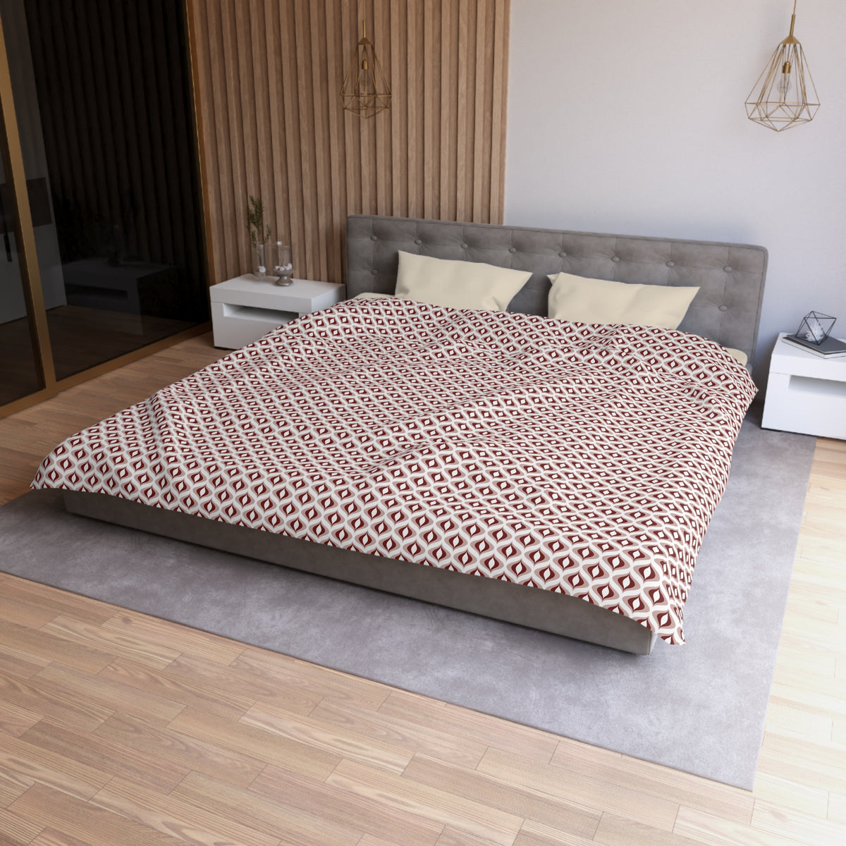 a modern bedroom with a large bed, a gray headboard, and a patterned comforter. The room has a wooden floor and white walls, creating a clean and minimalist aesthetic.