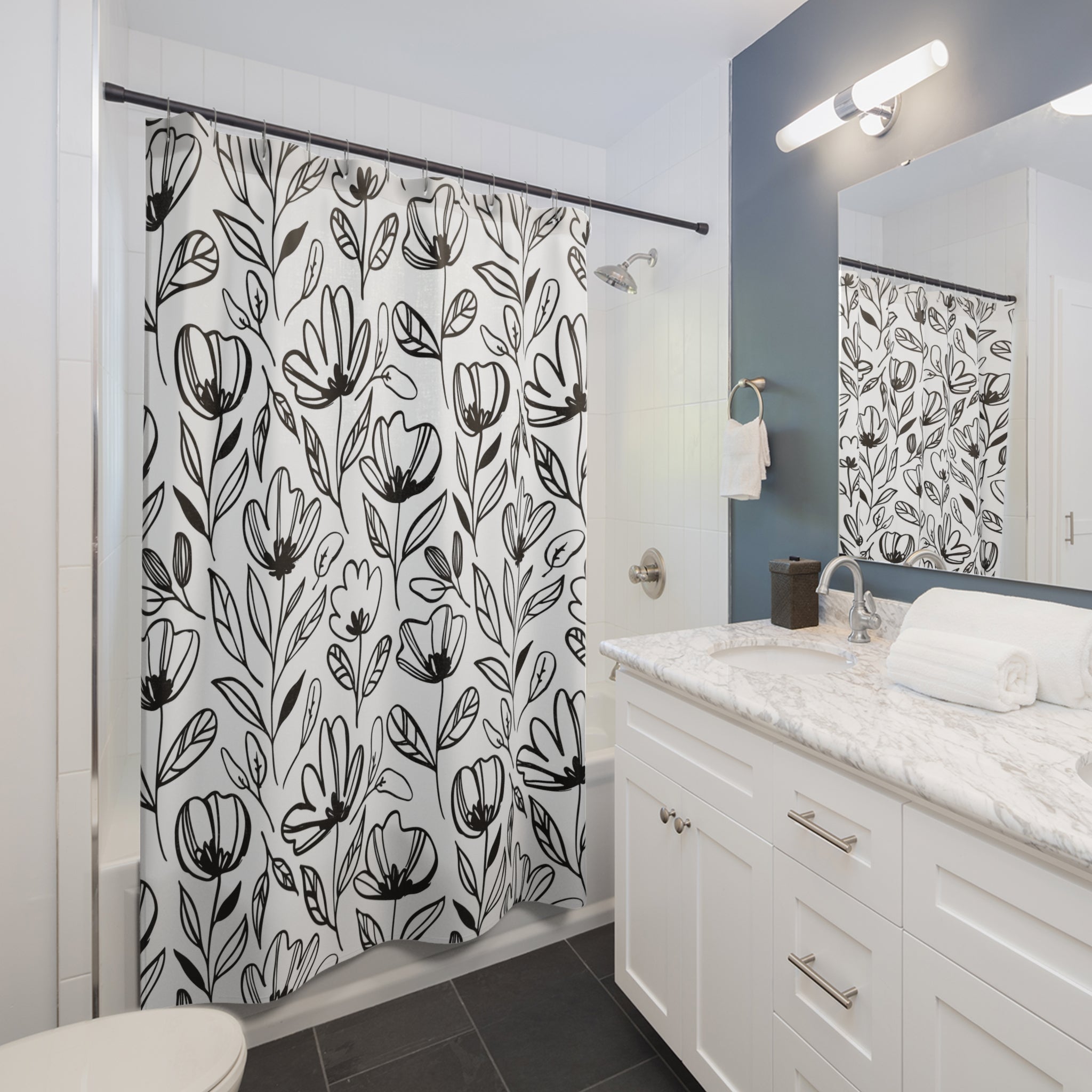 a bathroom with a shower curtain with black and white flowers on it