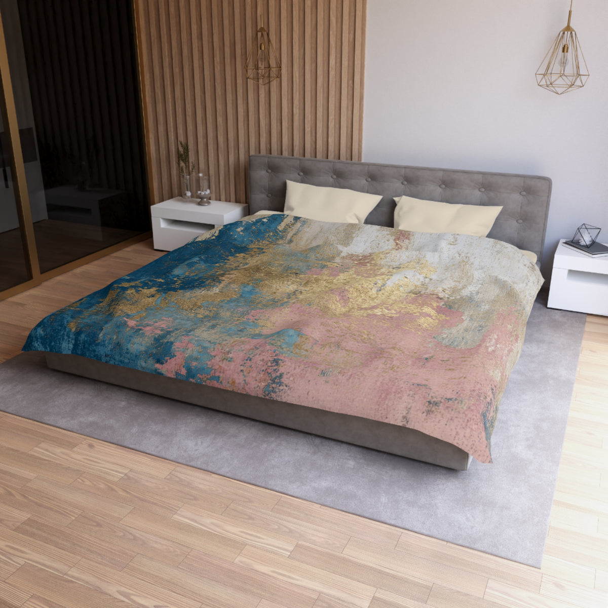 a modern bedroom with a large bed, a gray headboard, and a colorful abstract patterned comforter. The room has a wooden floor and white walls, creating a clean and minimalist aesthetic.