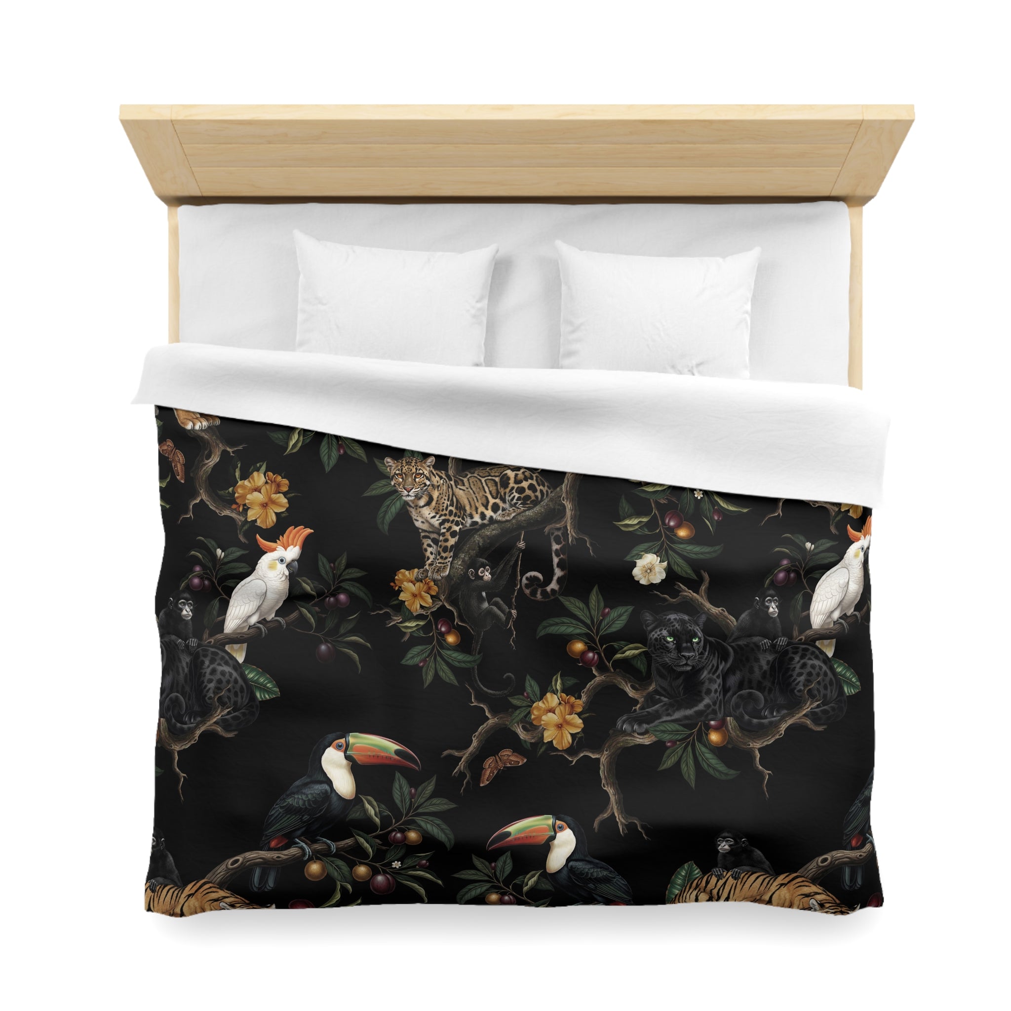 a bed with a black and white patterned comforter that includes various tropical animals such as a parrot, a jaguar, and a toucan.