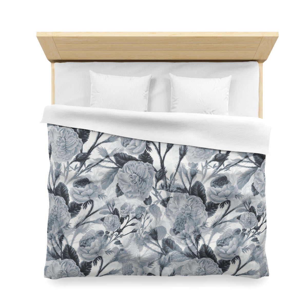 a neatly made bed with a floral patterned comforter and two white pillows.