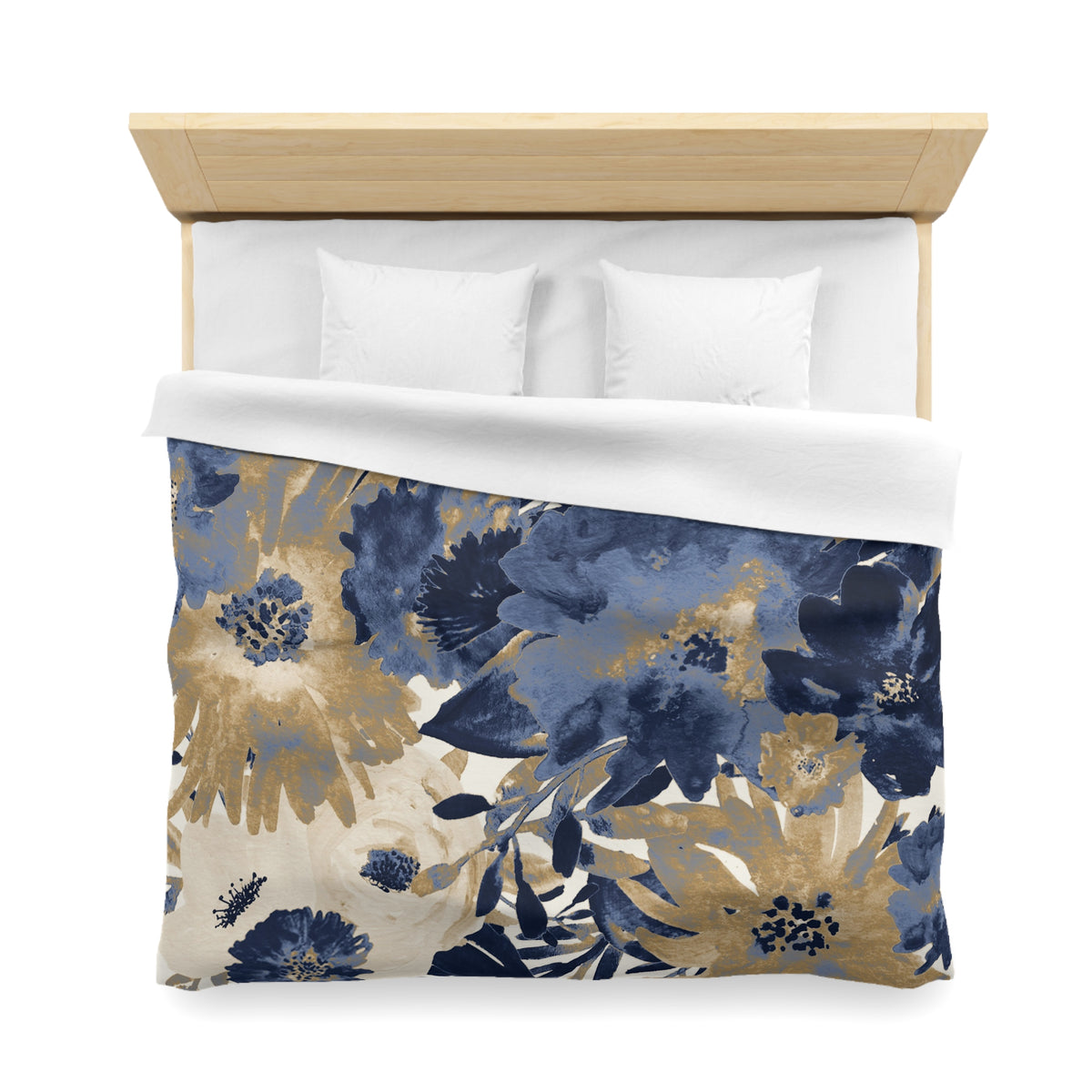a bed with a floral print duvet cover and white pillows. The duvet cover features a design of blue and gold flowers, creating a visually appealing and cozy appearance.