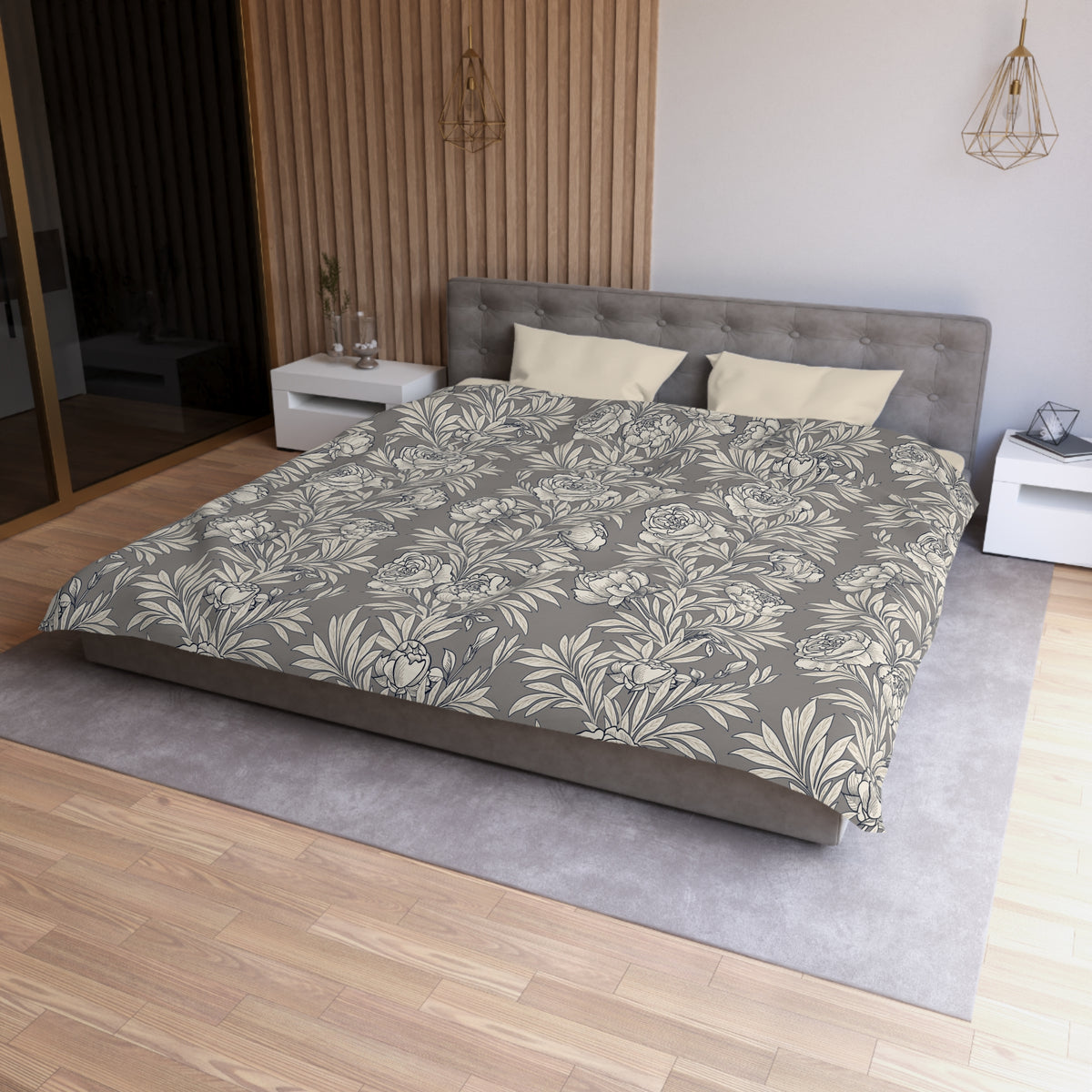 a modern bedroom with a large bed, a gray headboard, and a gray and white floral patterned comforter. The room has a wooden floor and white walls, creating a serene and elegant atmosphere.