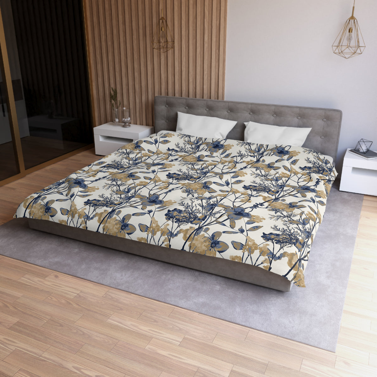 a modern bedroom with a large bed, a gray headboard, and a floral patterned comforter. The room has a wooden floor and white walls, creating a serene and elegant atmosphere.