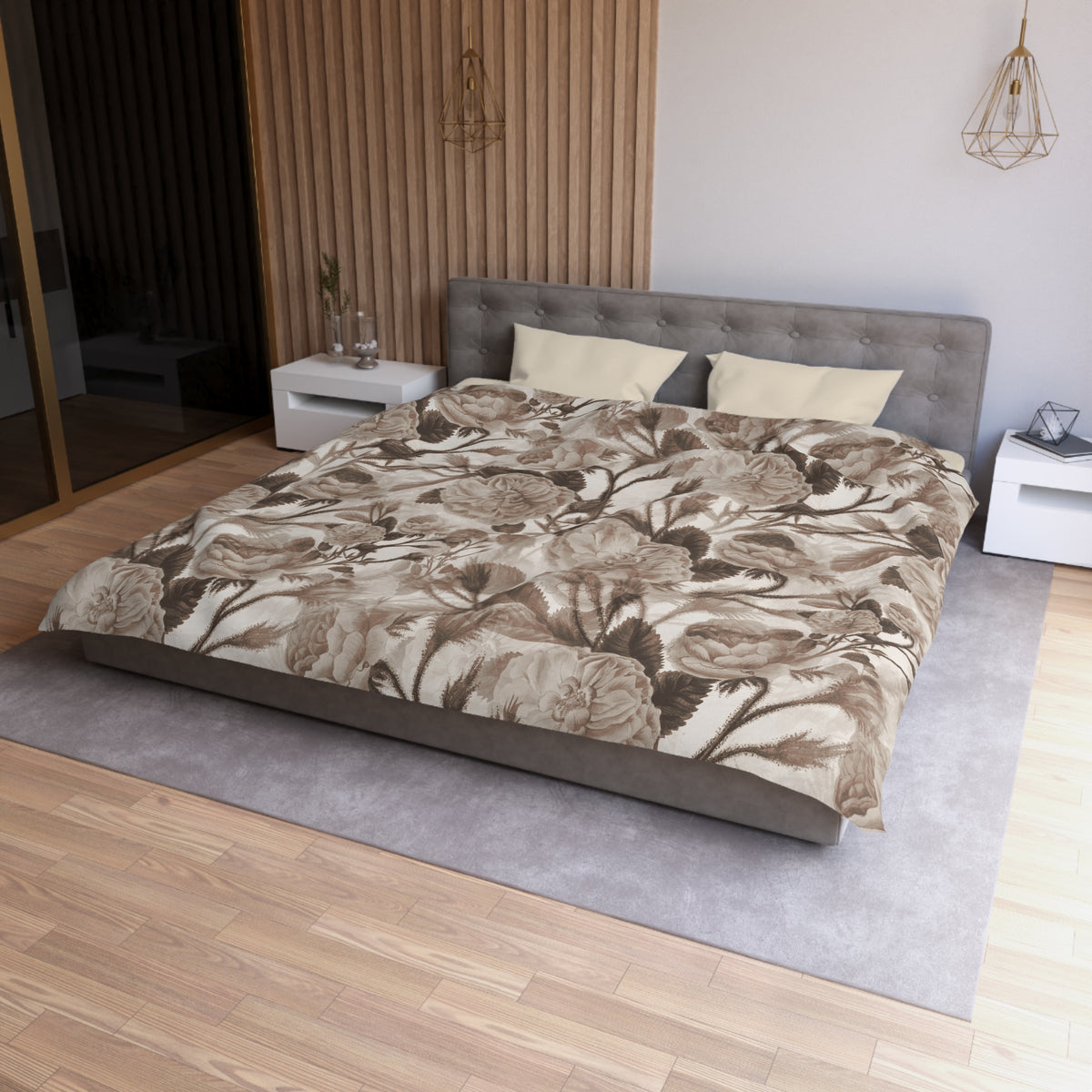 a modern bedroom with a large bed, a gray headboard, and a floral patterned comforter. The room has a wooden floor and white nightstands on either side of the bed. There is a pendant light hanging above the bed, and a vase on one of the nightstands. The overall design and decor of the room create a serene and stylish atmosphere.