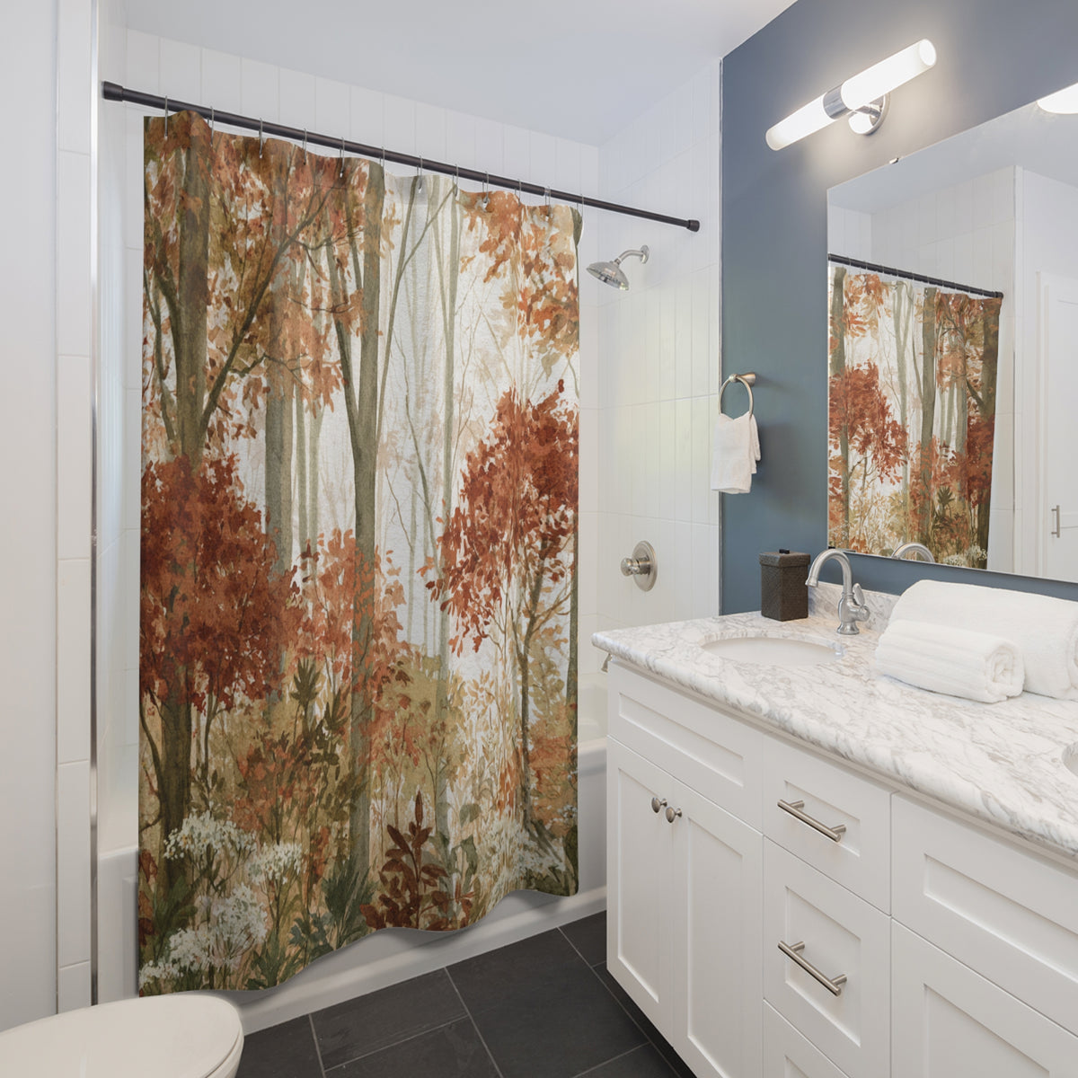 a bathroom with a shower curtain featuring a forest scene, a sink with a mirror above it, and a white vanity with drawers.