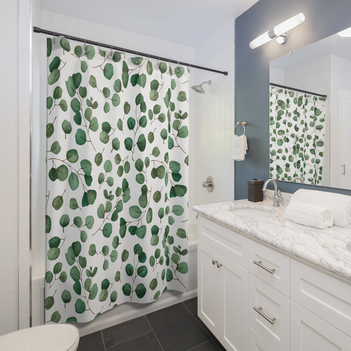 a modern bathroom with a white vanity, a green leaf-patterned shower curtain, and a mirror above the sink.