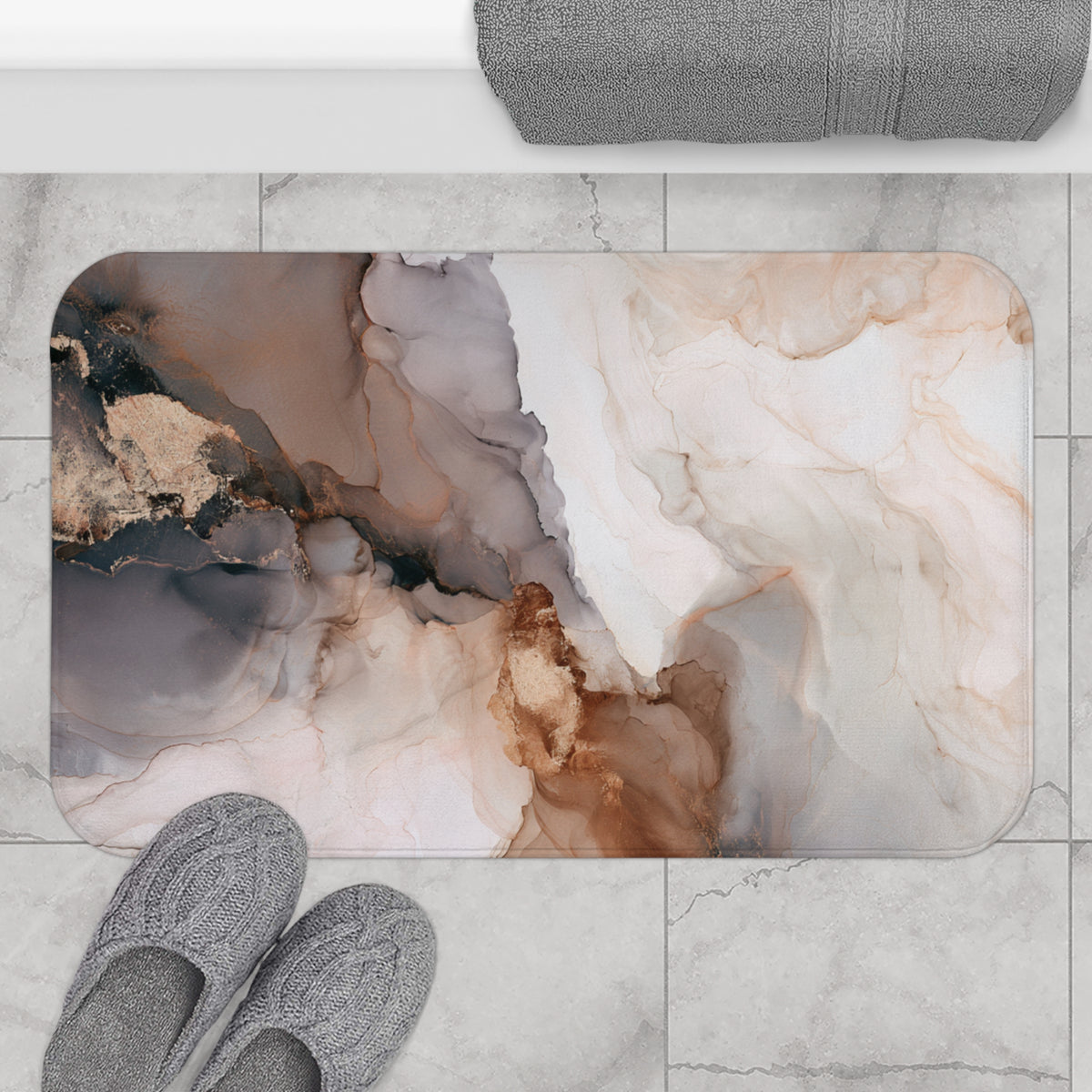 a bathroom mat with an abstract marble-like design in shades of brown, beige, and gray. The mat is placed on a tiled floor, and there are a pair of gray slippers positioned next to it.