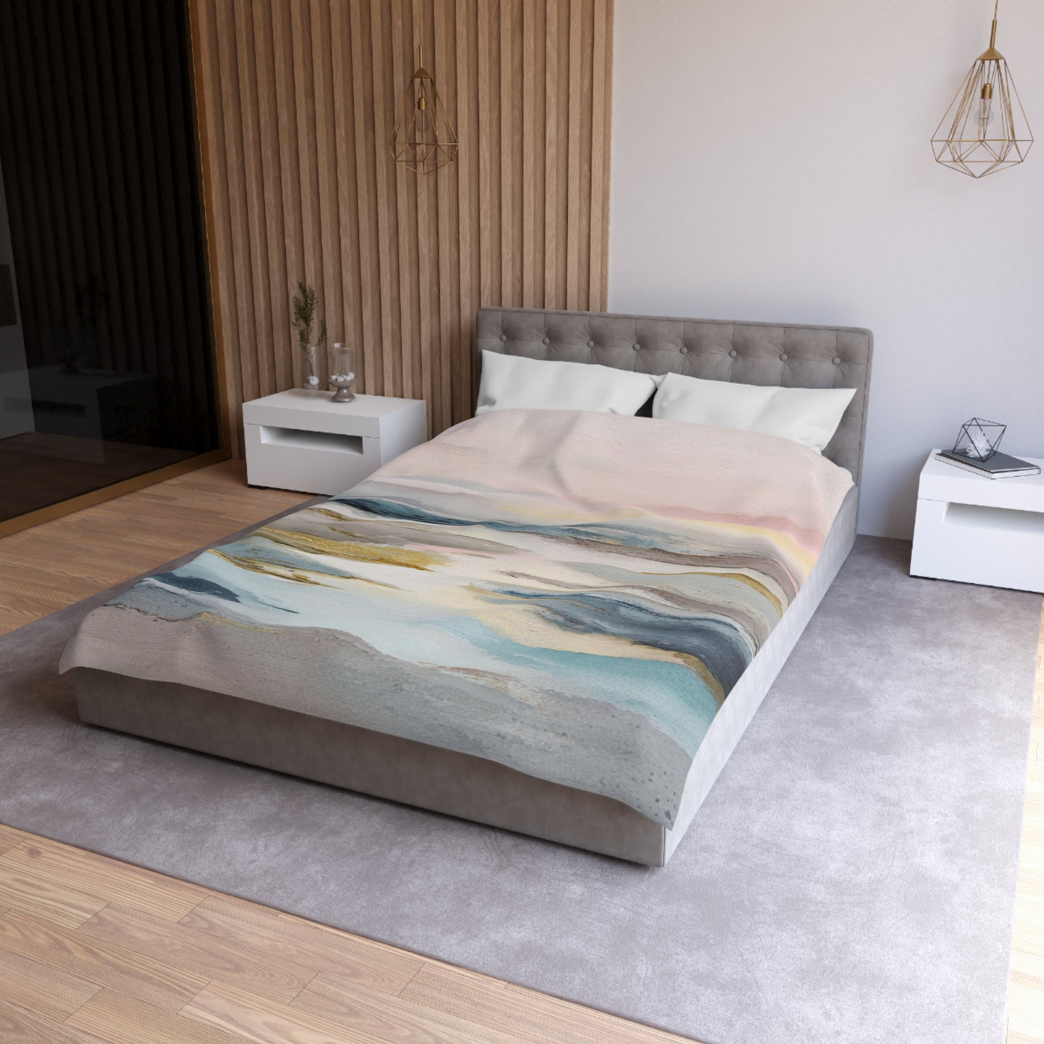 a modern bedroom with a gray tufted headboard, a gray bedspread with a colorful abstract design, and white nightstands on either side of the bed.