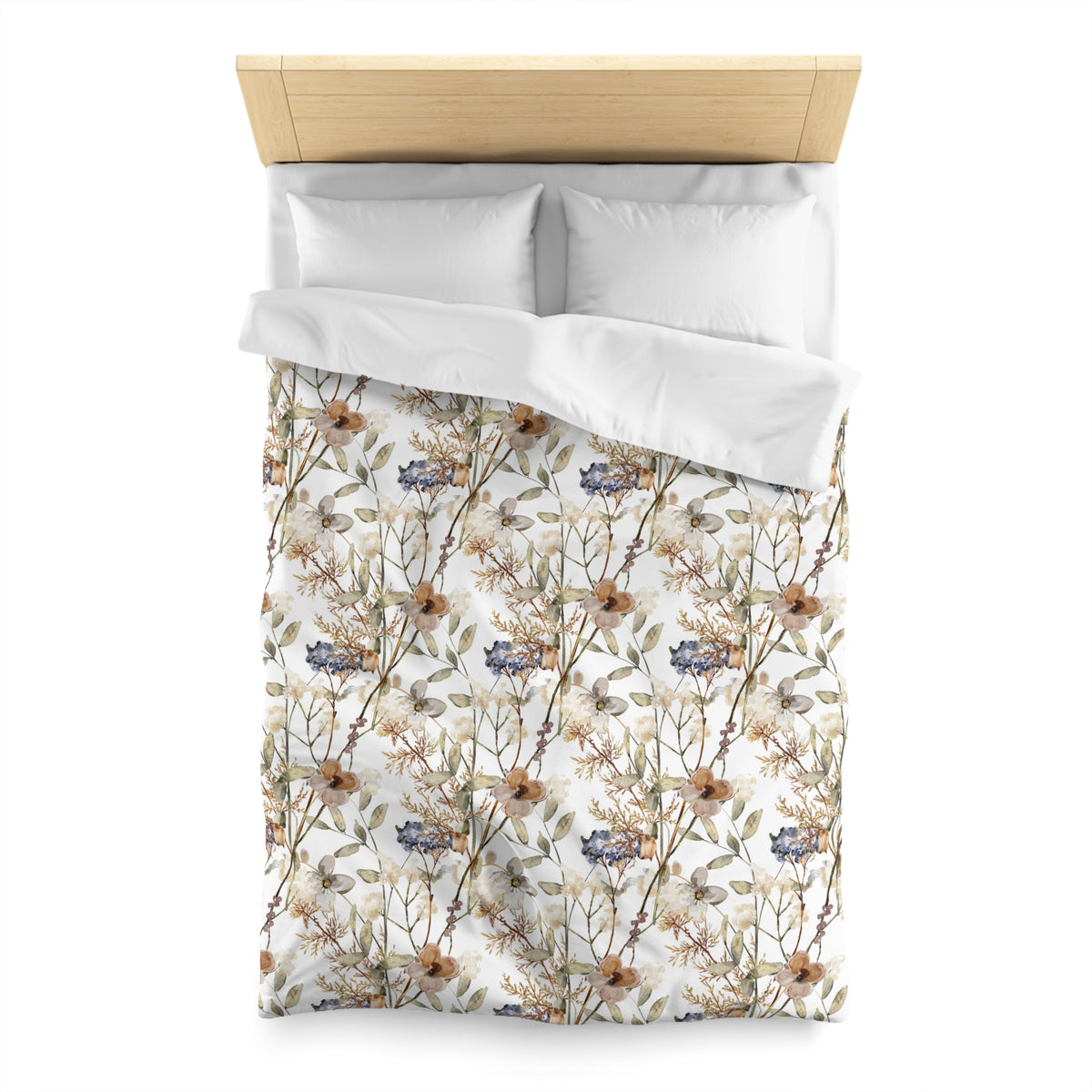 a neatly made bed with a floral print duvet cover and two white pillows.