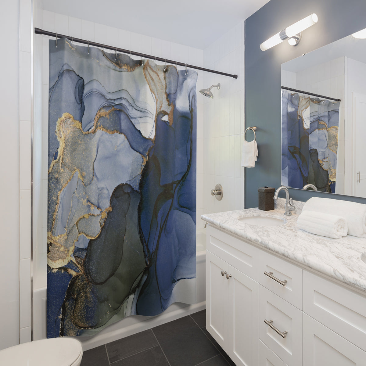 a modern bathroom with a white vanity, marble countertop, and a large blue and gold abstract shower curtain.