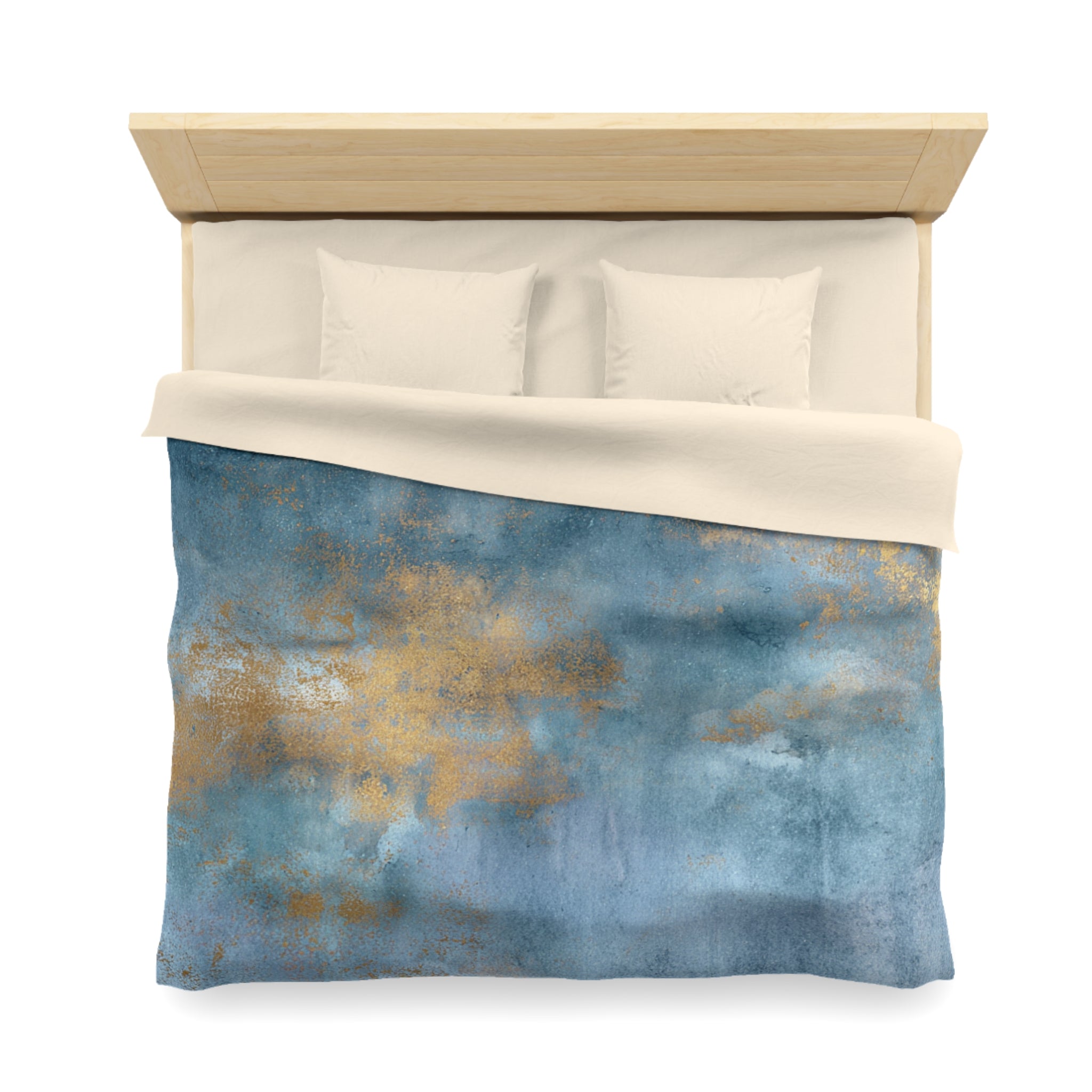 a neatly made bed with a blue and gold patterned comforter and two white pillows.