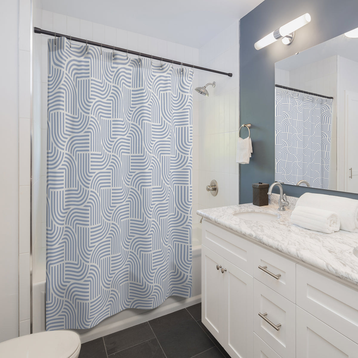 a modern bathroom with a white vanity, a blue and white patterned shower curtain, and a mirror above the sink.