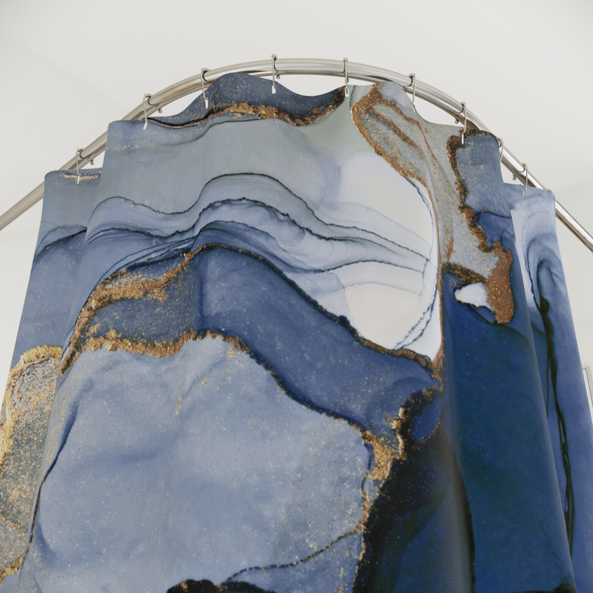 a shower curtain with a marble-like pattern in shades of blue and gold.