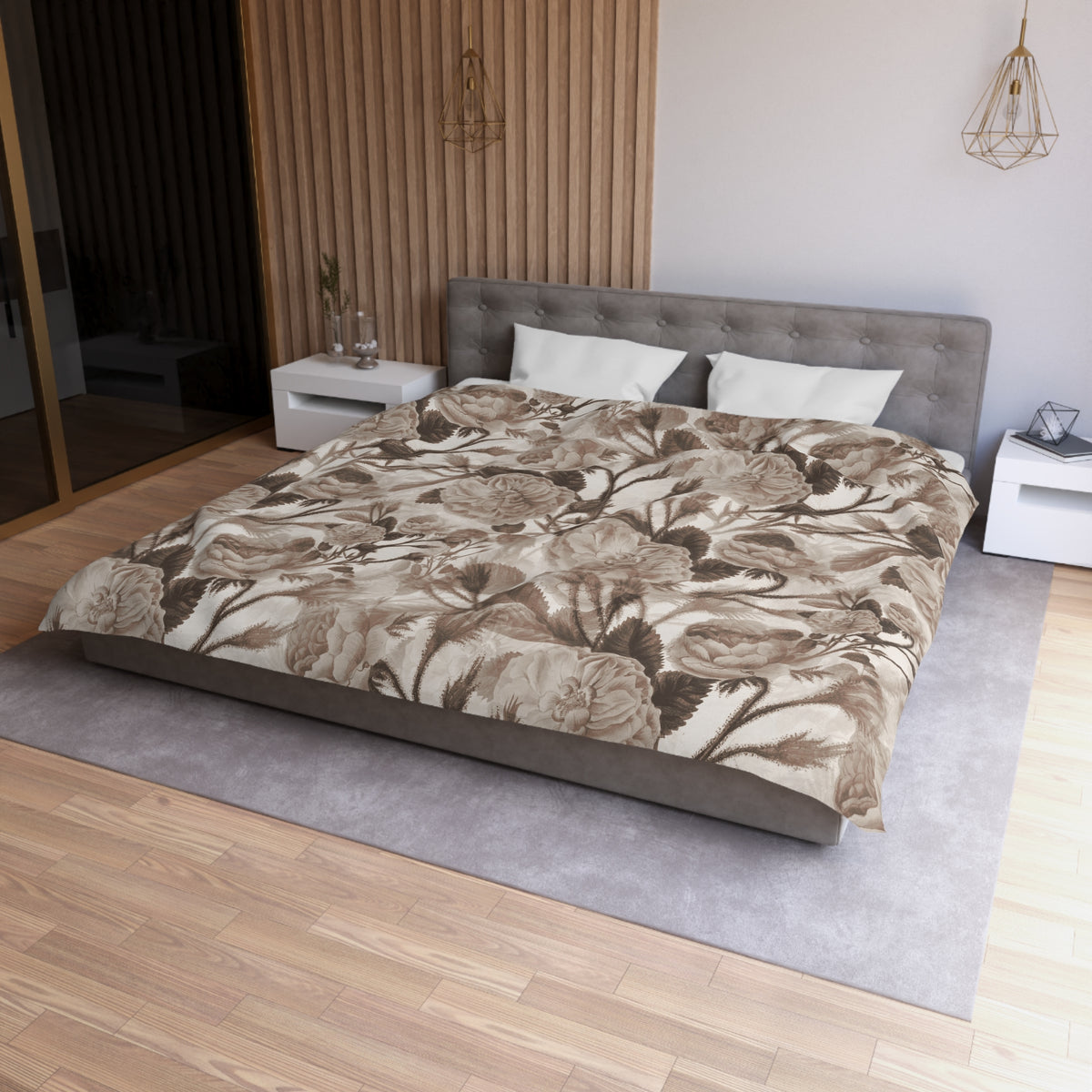 a modern bedroom with a large bed, a gray headboard, and a floral patterned comforter. The room has a wooden floor and white nightstands on either side of the bed. There is a pendant light hanging above the bed, and a vase on one of the nightstands. The overall design and decor of the room create a serene and stylish atmosphere.