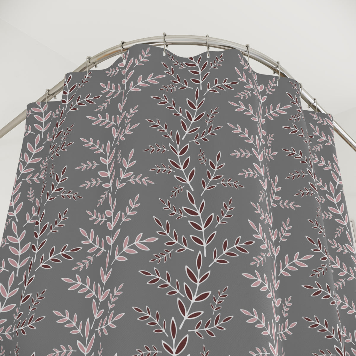 a gray shower curtain with a repeating pattern of pink and white leaves on a gray background.