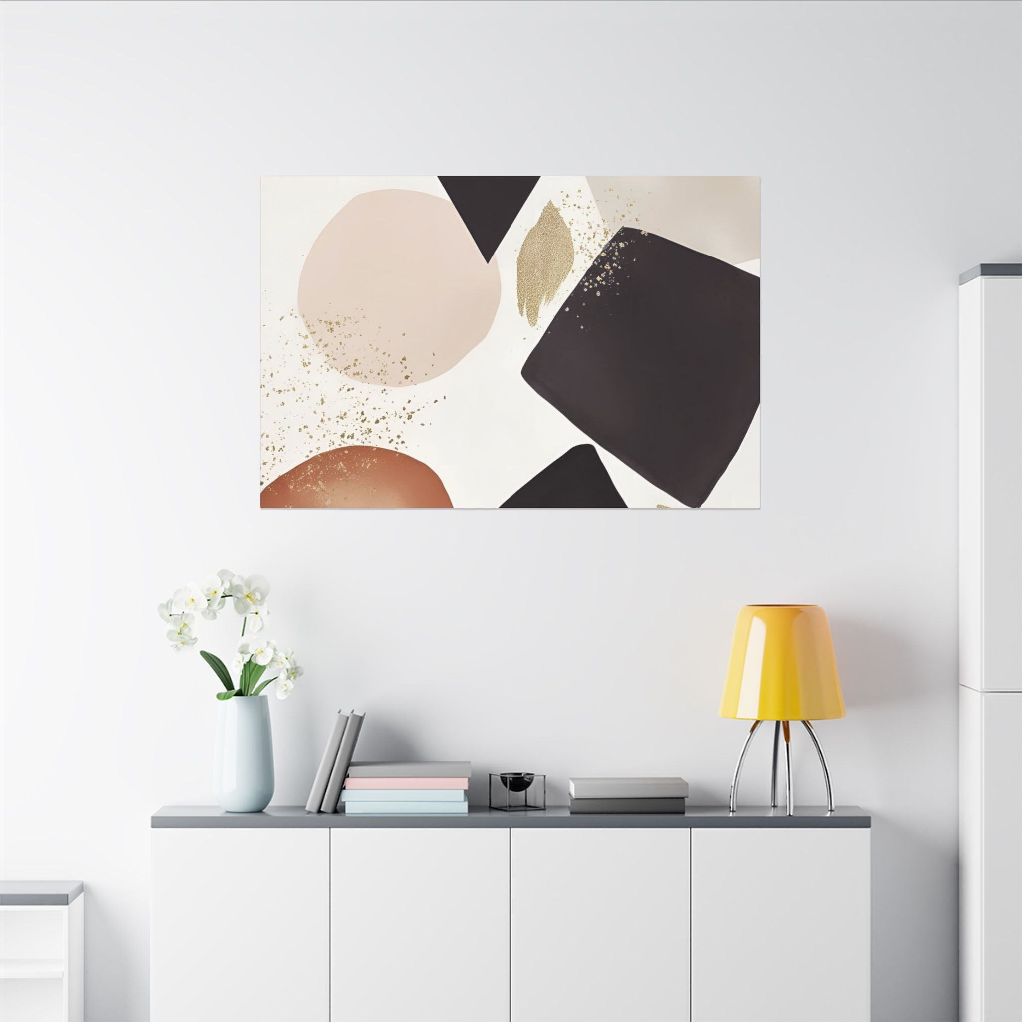 a minimalist living space with a white wall, a white cabinet, a yellow lamp, a vase with white flowers, and a framed abstract art piece above the cabinet.