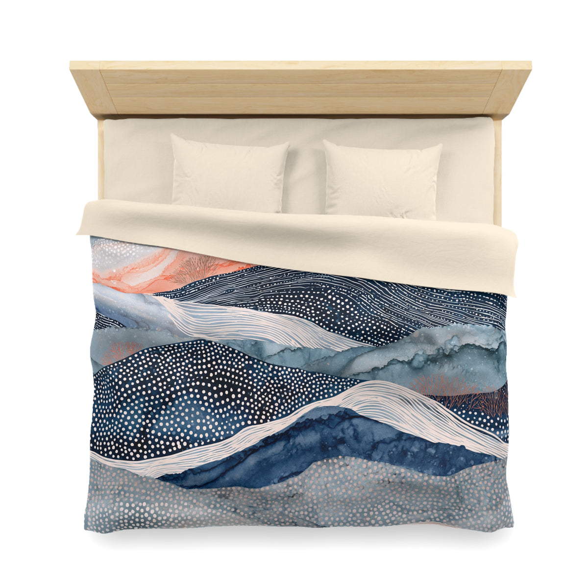 a bed with a decorative comforter featuring a mountain landscape design in shades of blue, white, and orange.