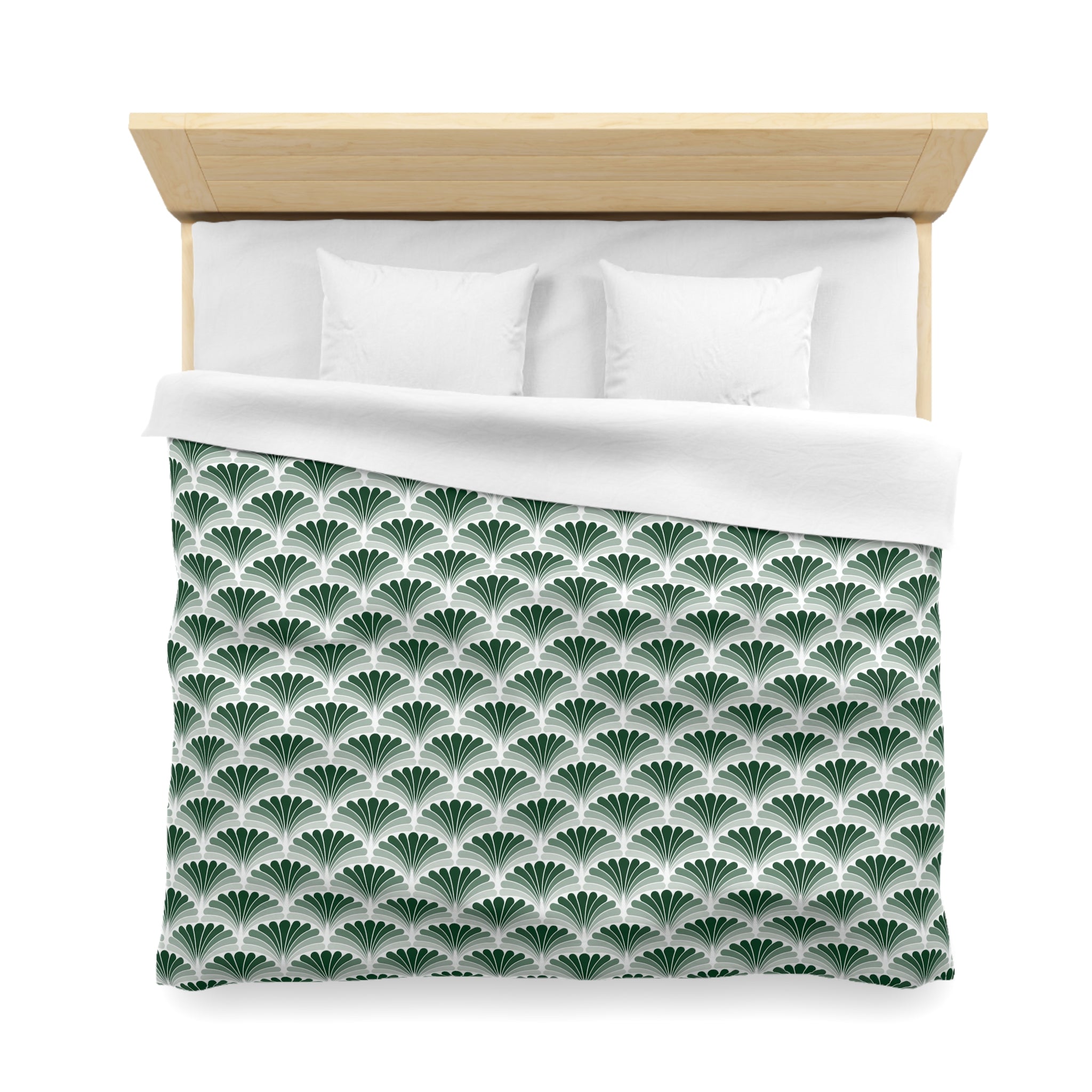 a neatly made bed with a green and white patterned comforter and two white pillows.