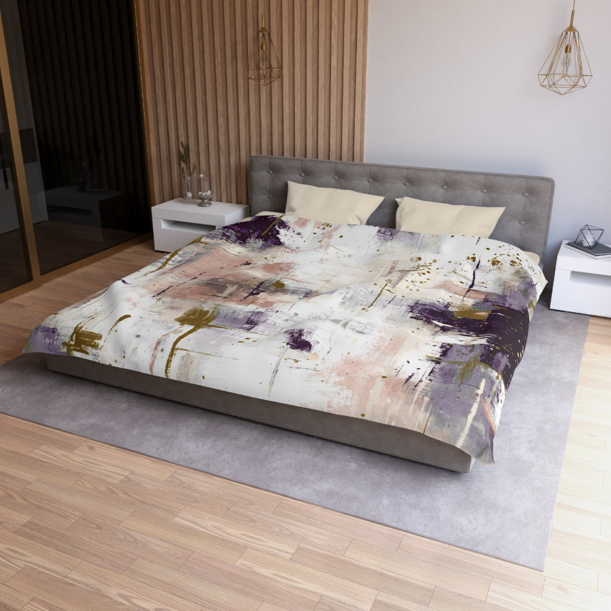 a modern bedroom with a large bed, a gray headboard, and a colorful abstract patterned comforter. The room has a wooden floor and white walls, creating a clean and minimalist aesthetic.