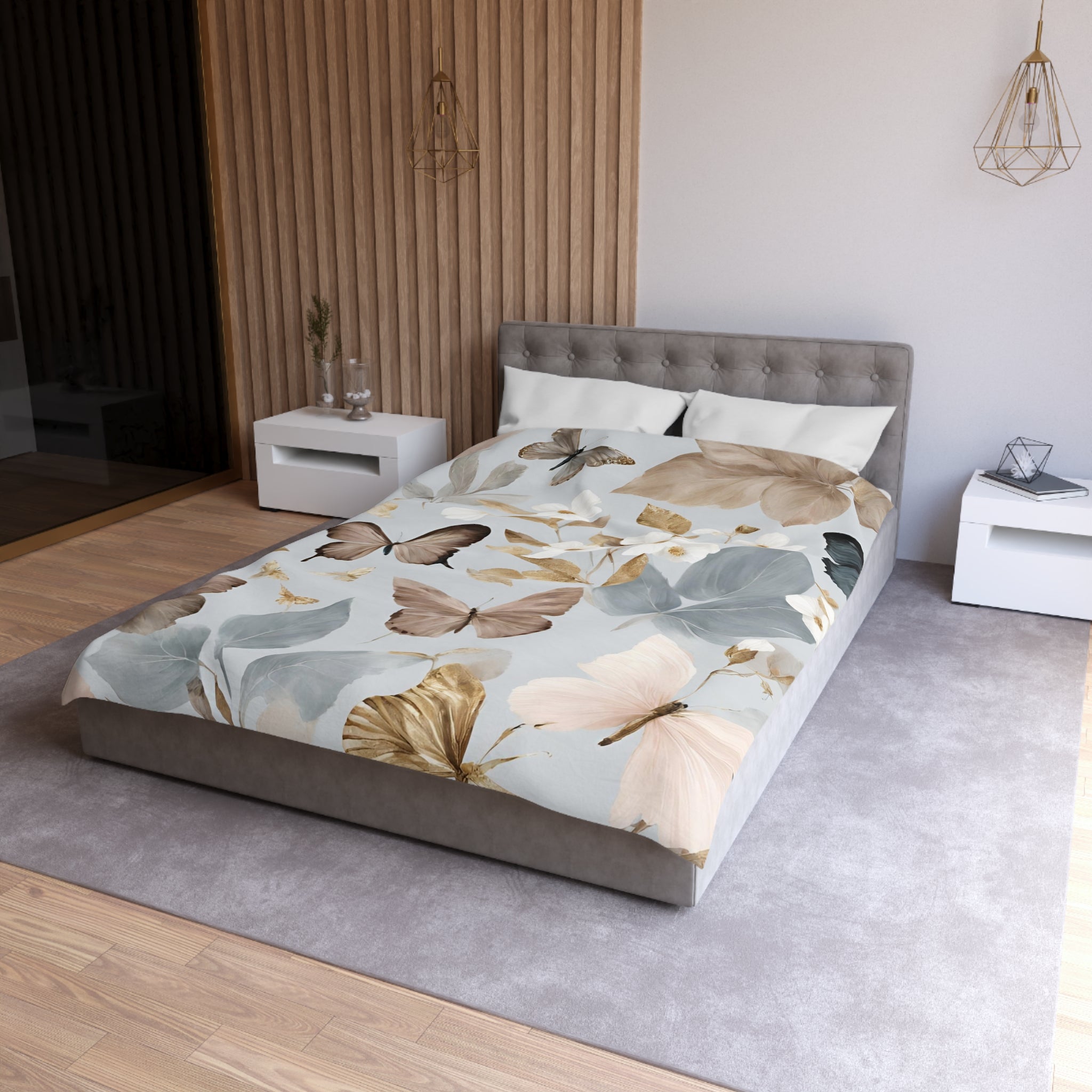 a modern bedroom with a large bed covered in a floral print comforter featuring butterflies and leaves in shades of blue, green, and brown. The bed is positioned against a wall with a wooden panel design, and there are two nightstands on either side of the bed. The room has a neutral color scheme with a gray carpet and white furniture, creating a serene and inviting atmosphere.