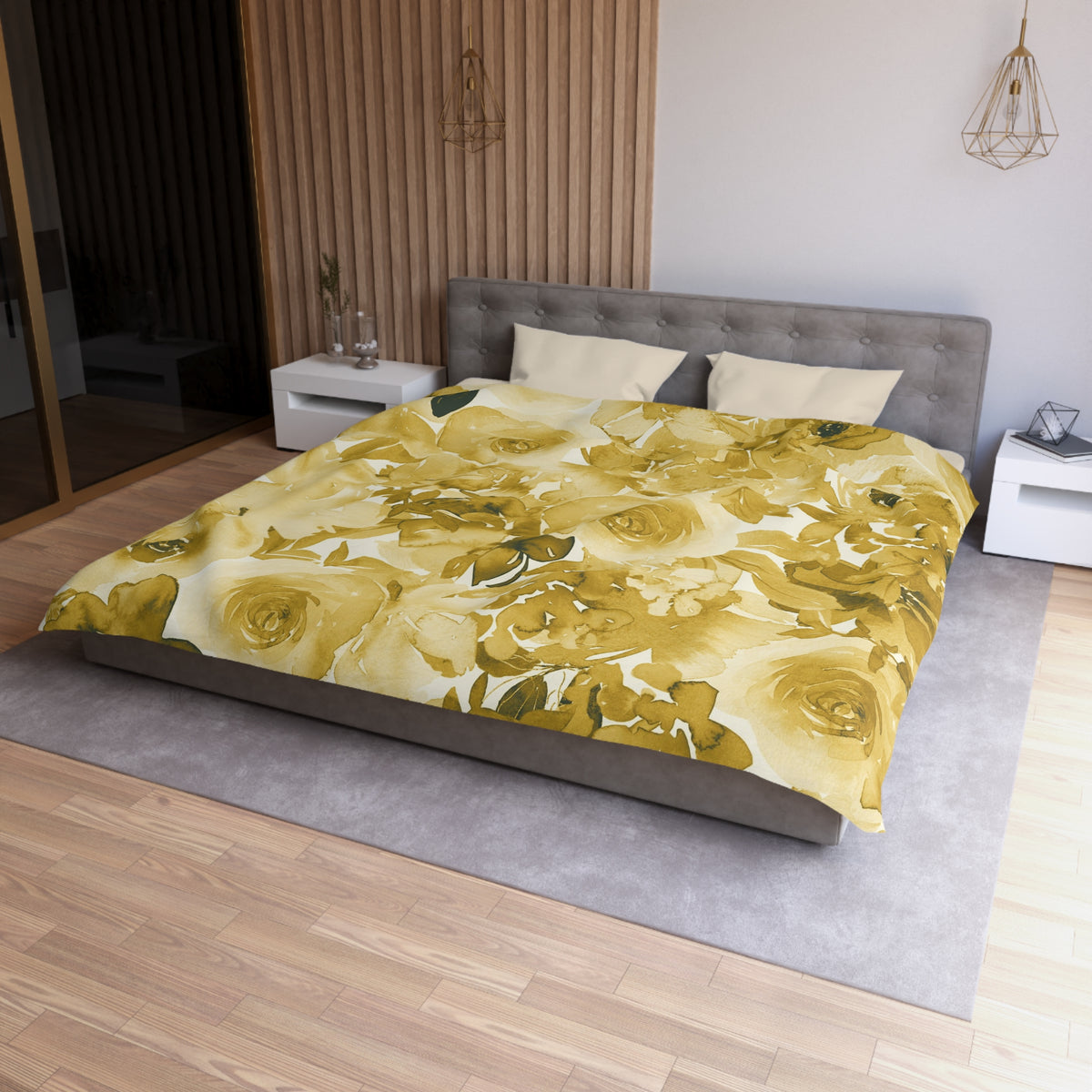 a modern bedroom with a large bed covered in a yellow floral comforter. The bed is positioned against a wall with a wooden panel. The room also features a nightstand, a pendant light, and a vase on a surface.