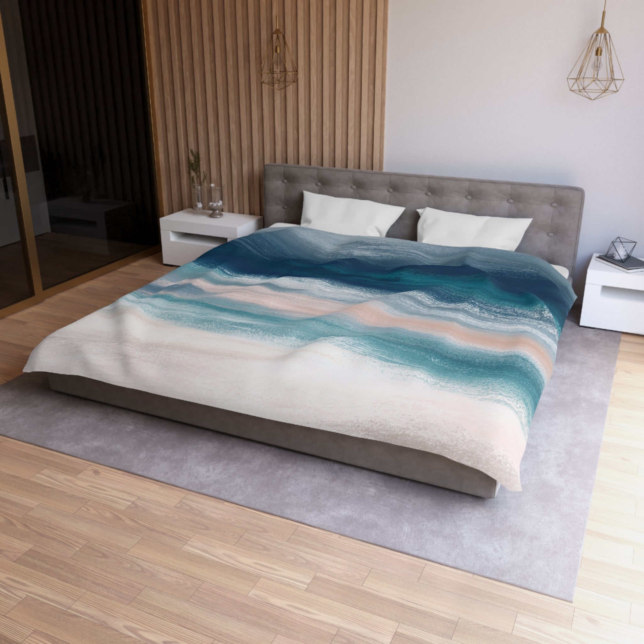 a modern bedroom with a large bed, a gray headboard, and a colorful abstract patterned comforter. The room has a wooden floor and white walls, creating a serene and stylish atmosphere.