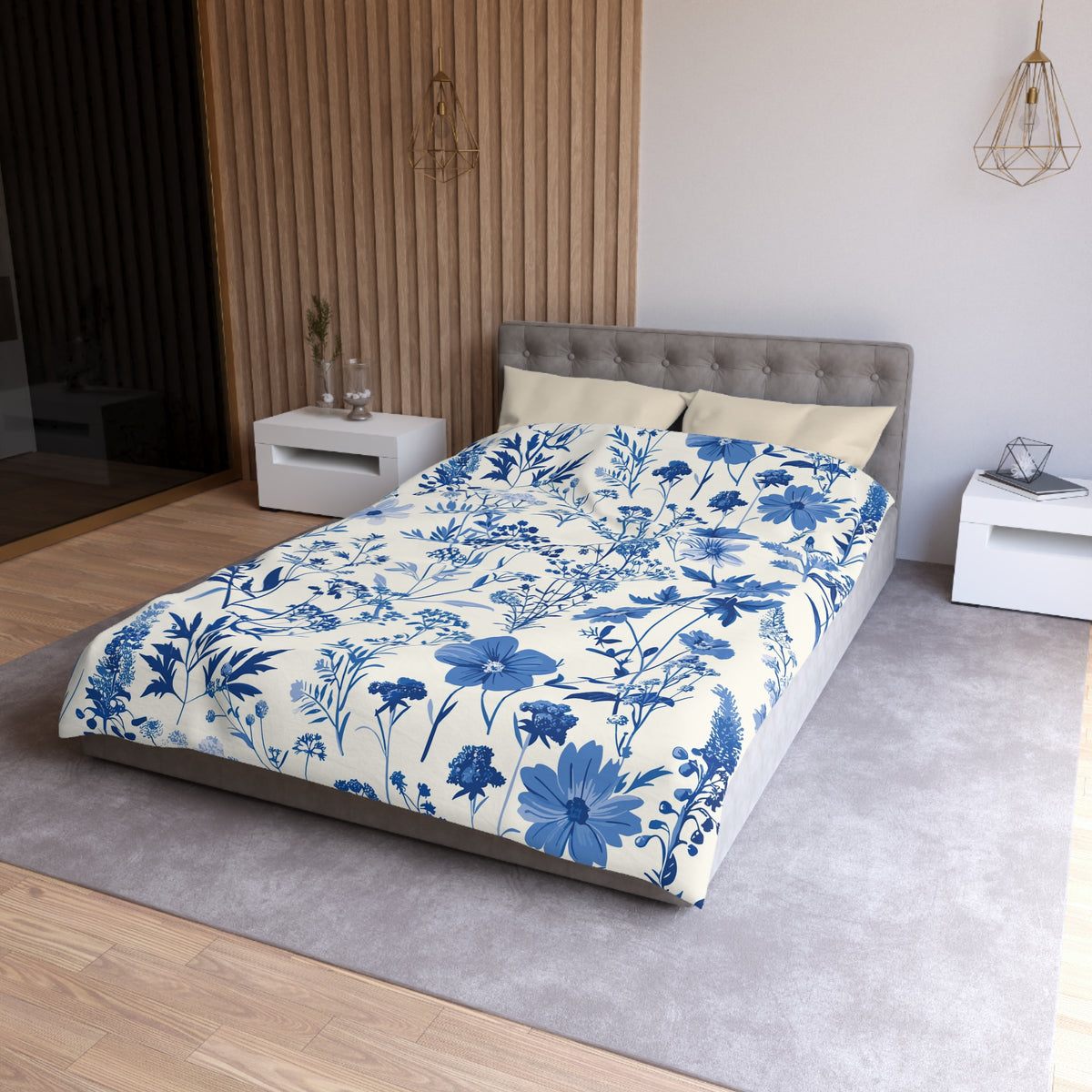 a modern bedroom with a large bed covered in a blue and white floral patterned comforter. The bed is positioned against a wall with a wooden panel design. The room also includes a nightstand and a pendant light fixture, creating a cozy and stylish atmosphere.