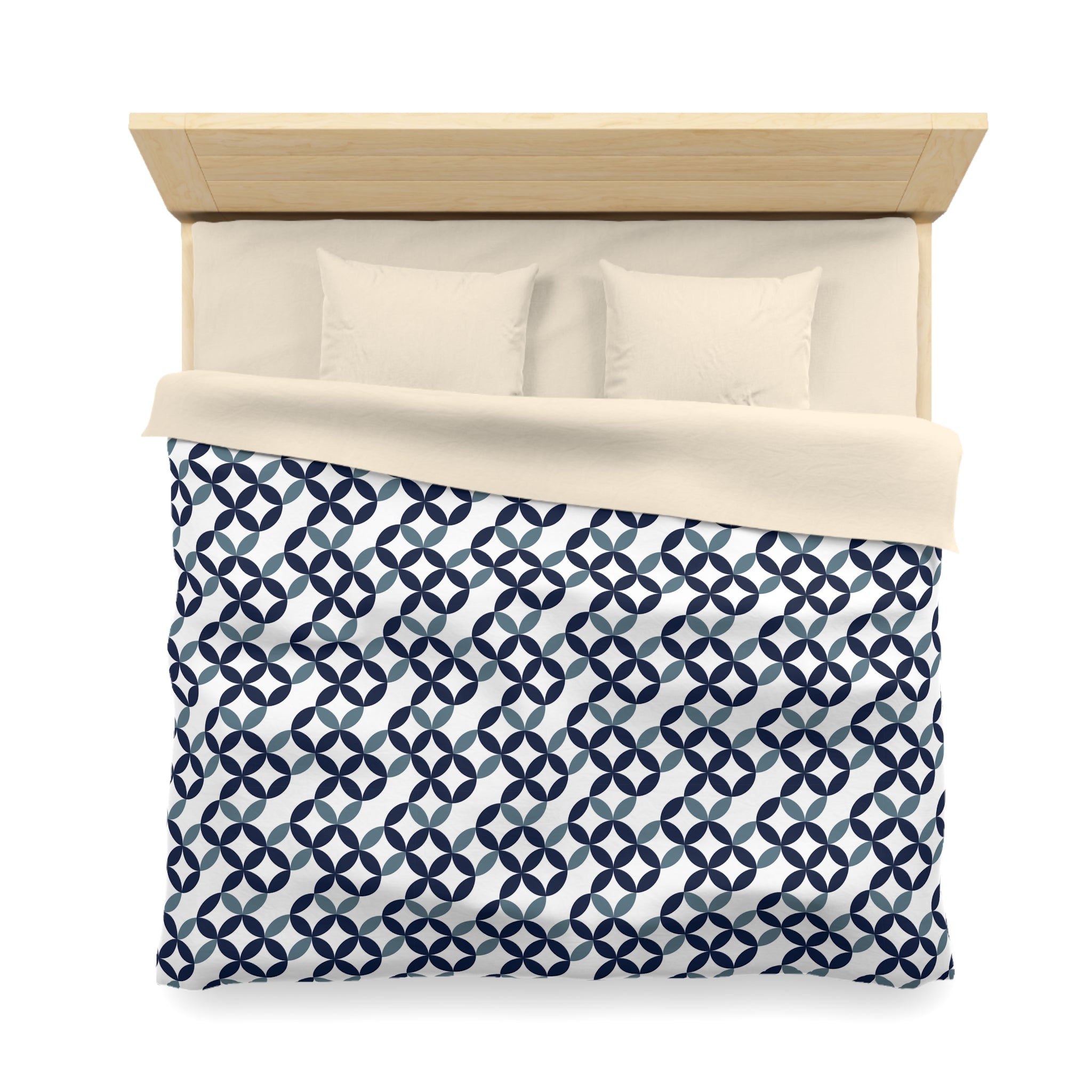 a neatly made bed with a blue and white patterned comforter and two pillows.