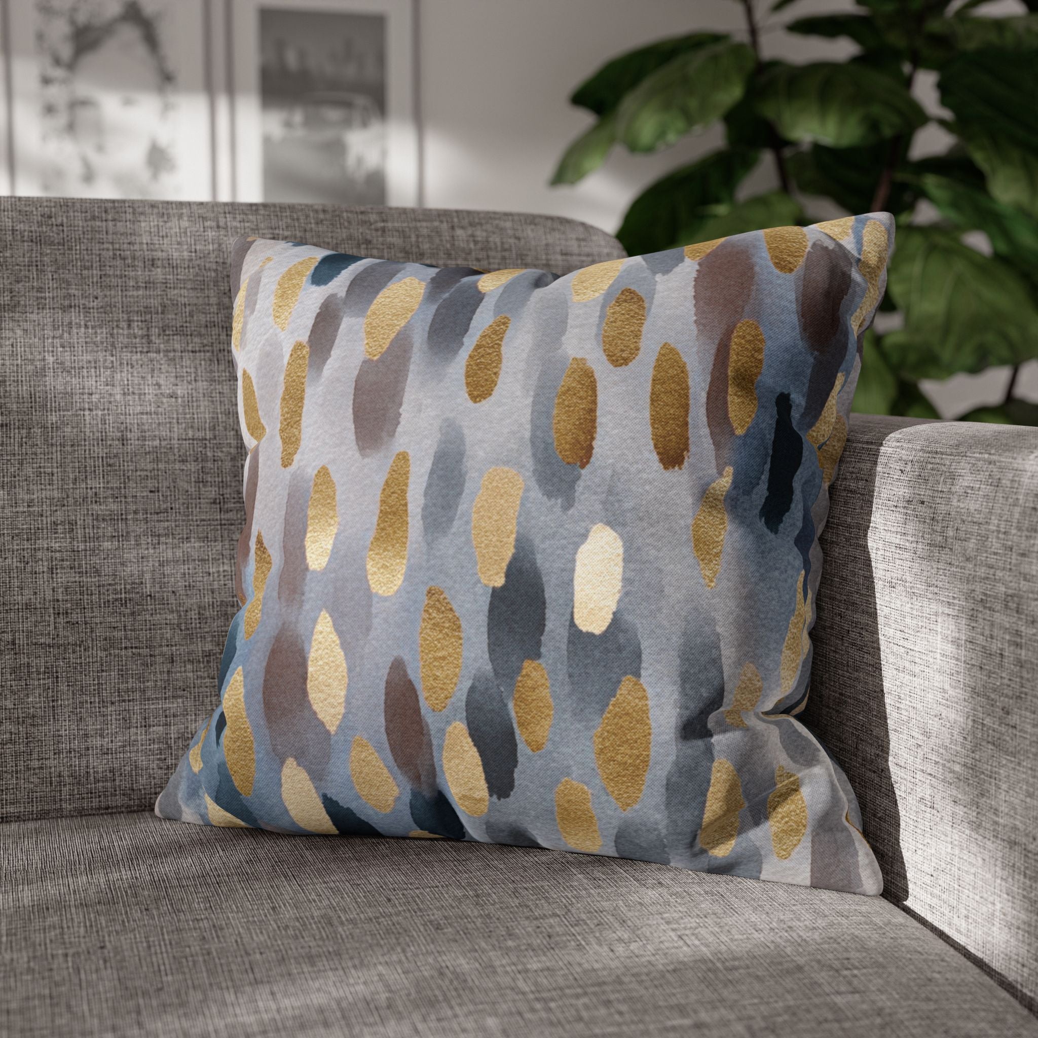 a gray sofa with a decorative throw pillow featuring a pattern of blue and gold circles.