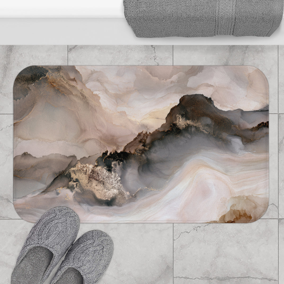 a bathroom mat with a marble-like texture and a landscape-inspired abstract design, placed on a tiled floor. Next to the mat, there are a pair of gray slippers.