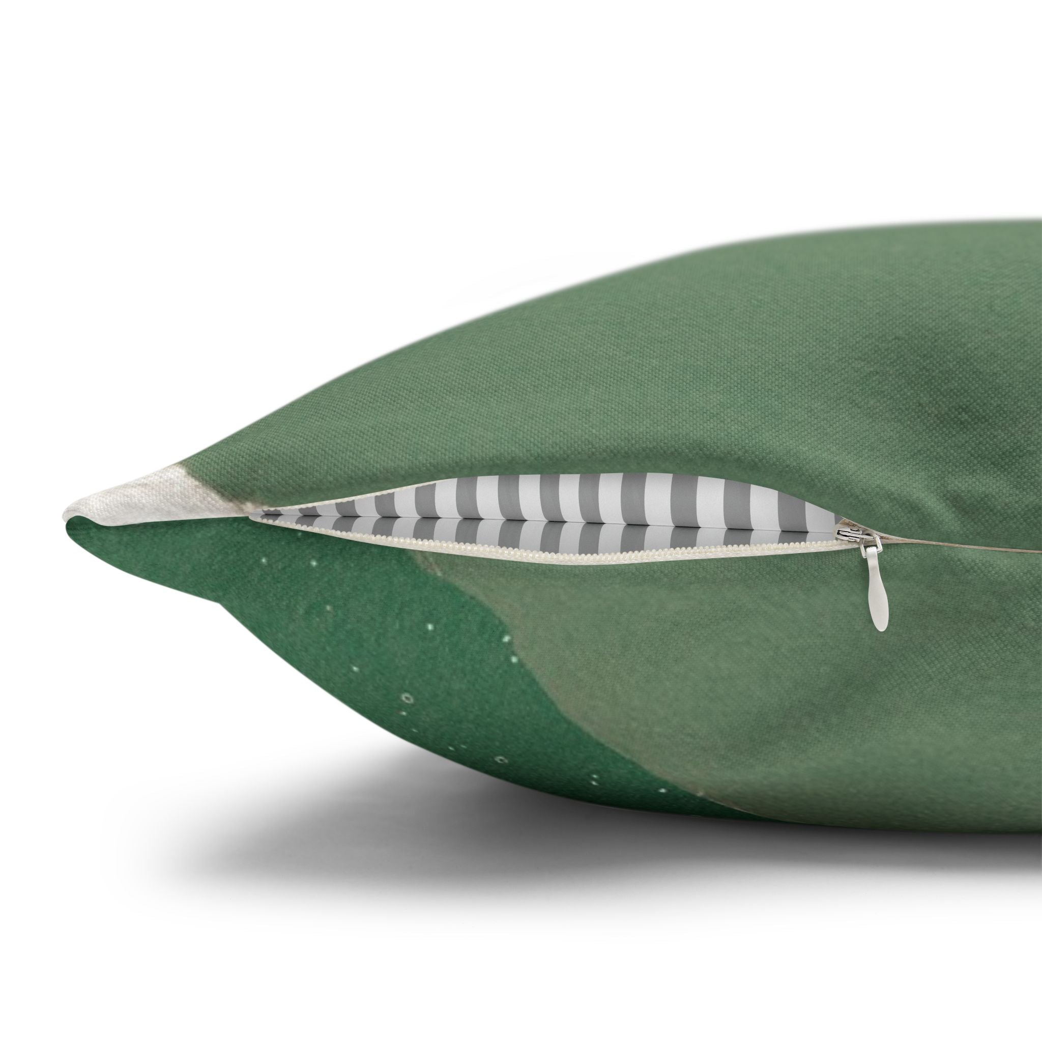 A close-up view of a green and white striped pillow with a zipper visible.