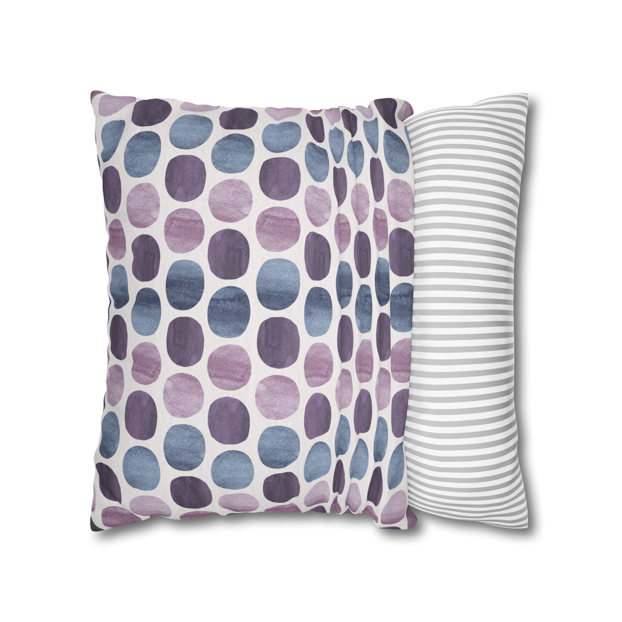 two pillows with different patterns: one with a polka dot pattern in shades of purple and blue, and the other with a striped pattern in gray and white.