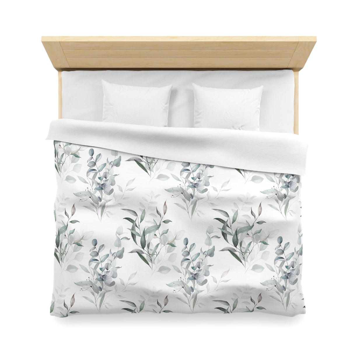 a neatly made bed with a white comforter and pillows, featuring a pattern of green leaves and flowers.