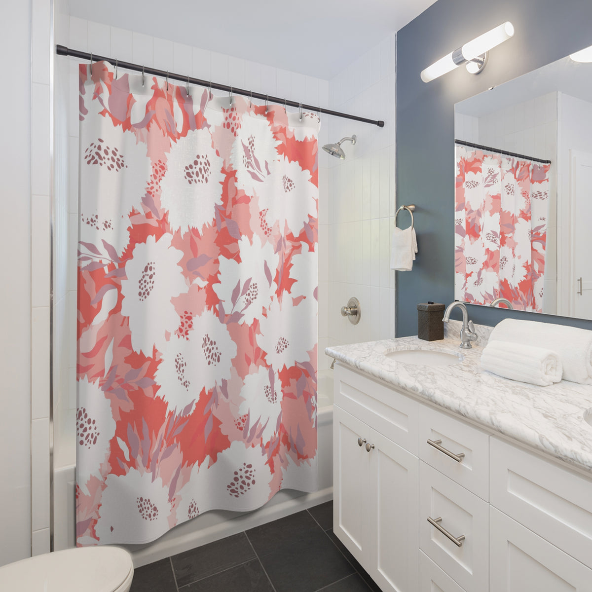 a modern bathroom with a white vanity, a shower curtain with a floral pattern in shades of pink and white, and a mirror above the vanity.