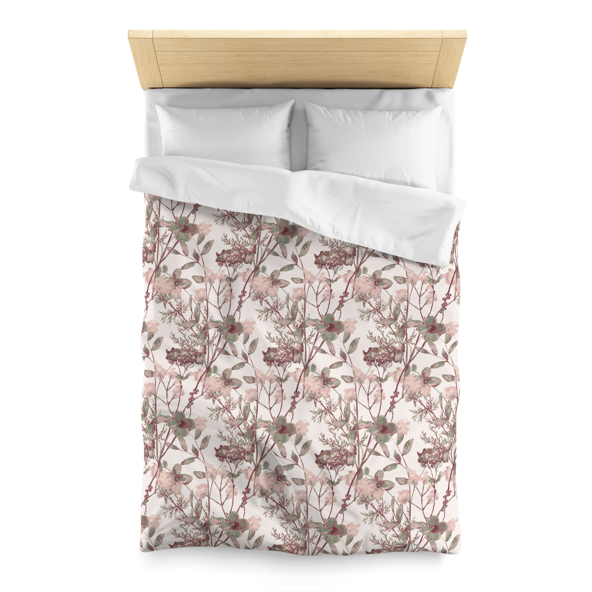 a neatly made bed with a floral print comforter and pillows.
