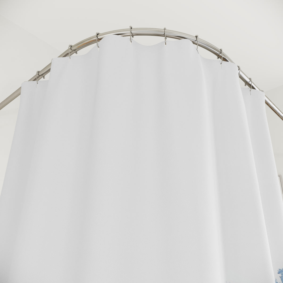 a white shower curtain hanging from a curved metal rod.