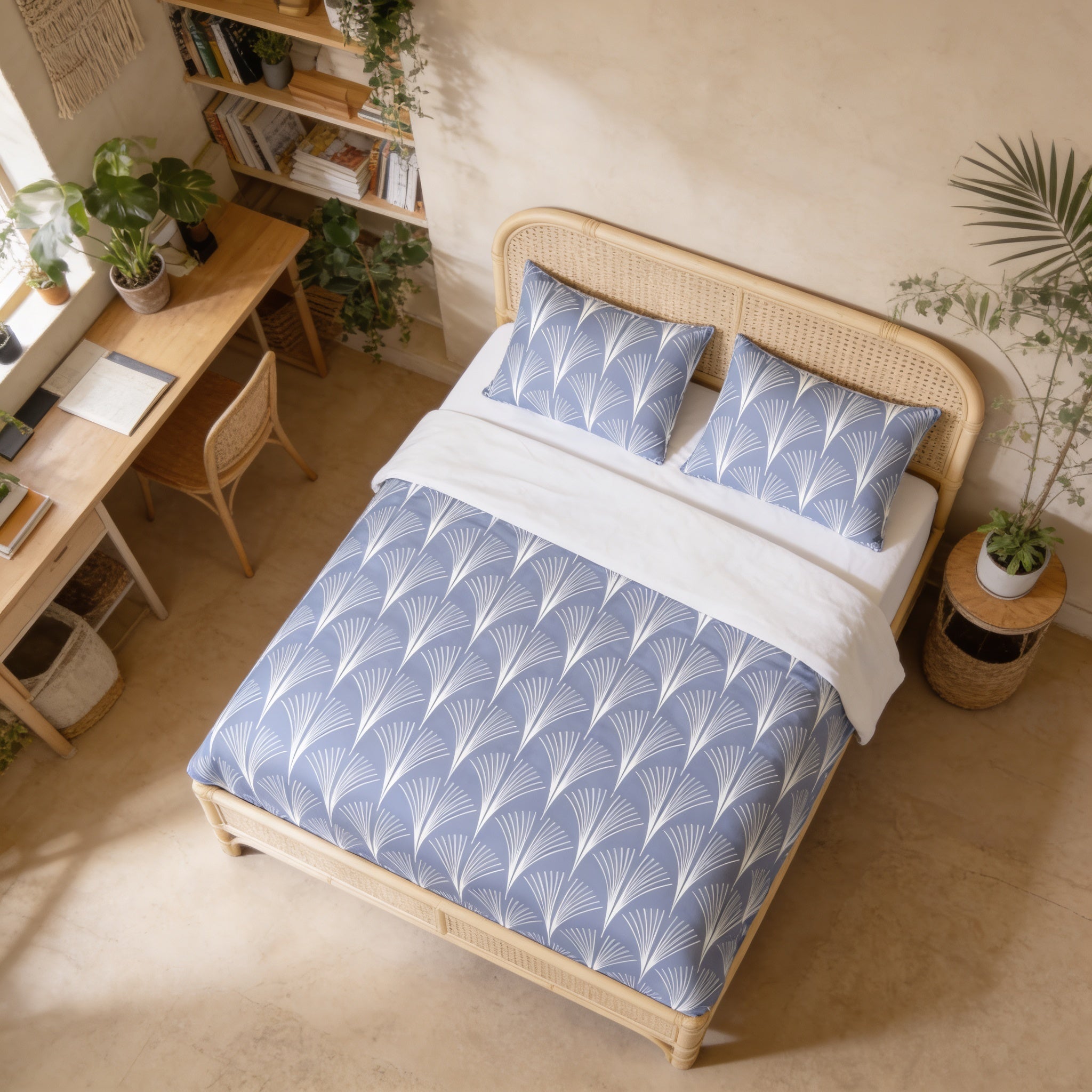 a bedroom with a bed, a desk, and various plants. The bed has a blue and white patterned comforter and matching pillows. The desk is positioned next to the bed, and there are several books and plants in the room.
