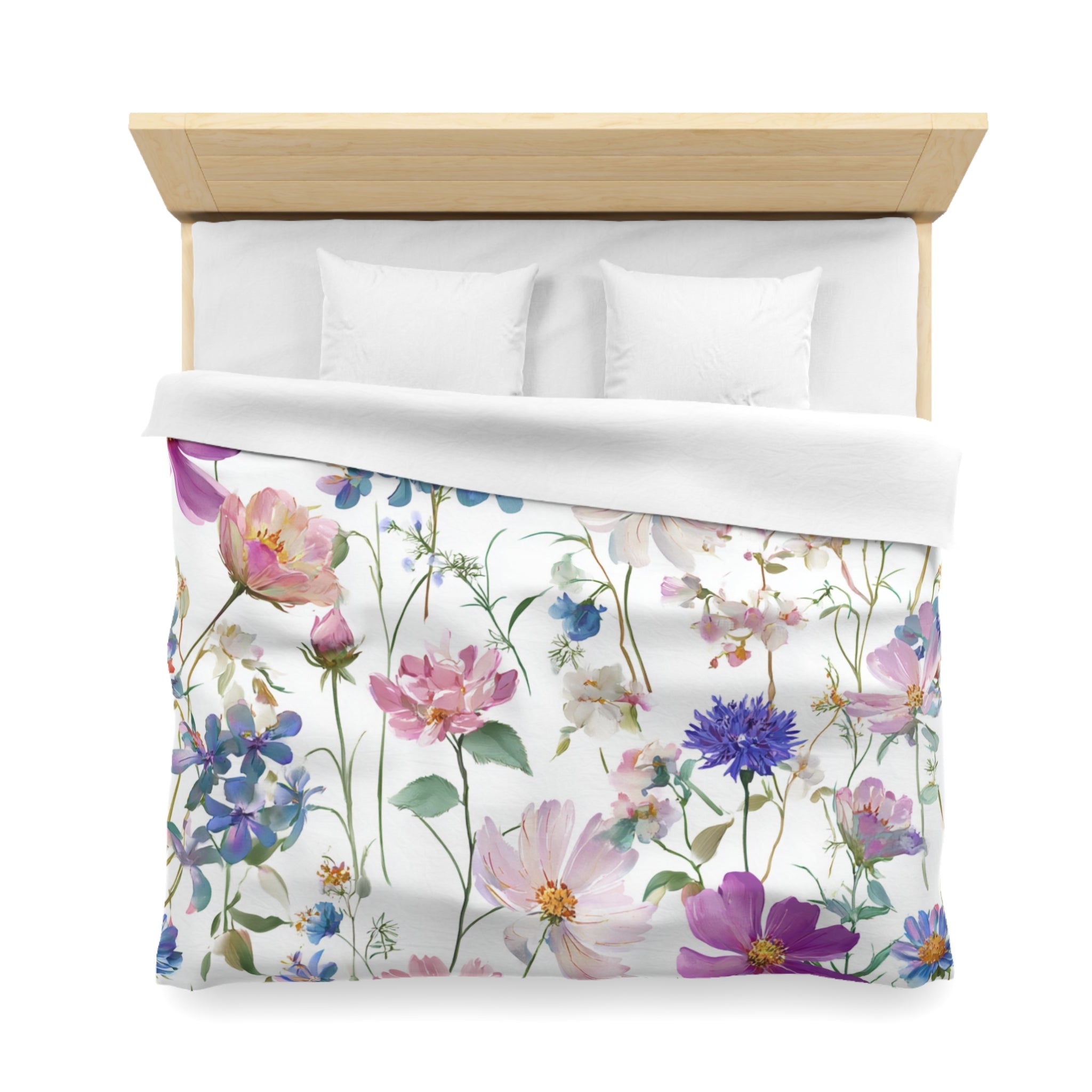 a bed with a floral print duvet cover featuring a variety of colorful flowers and plants.