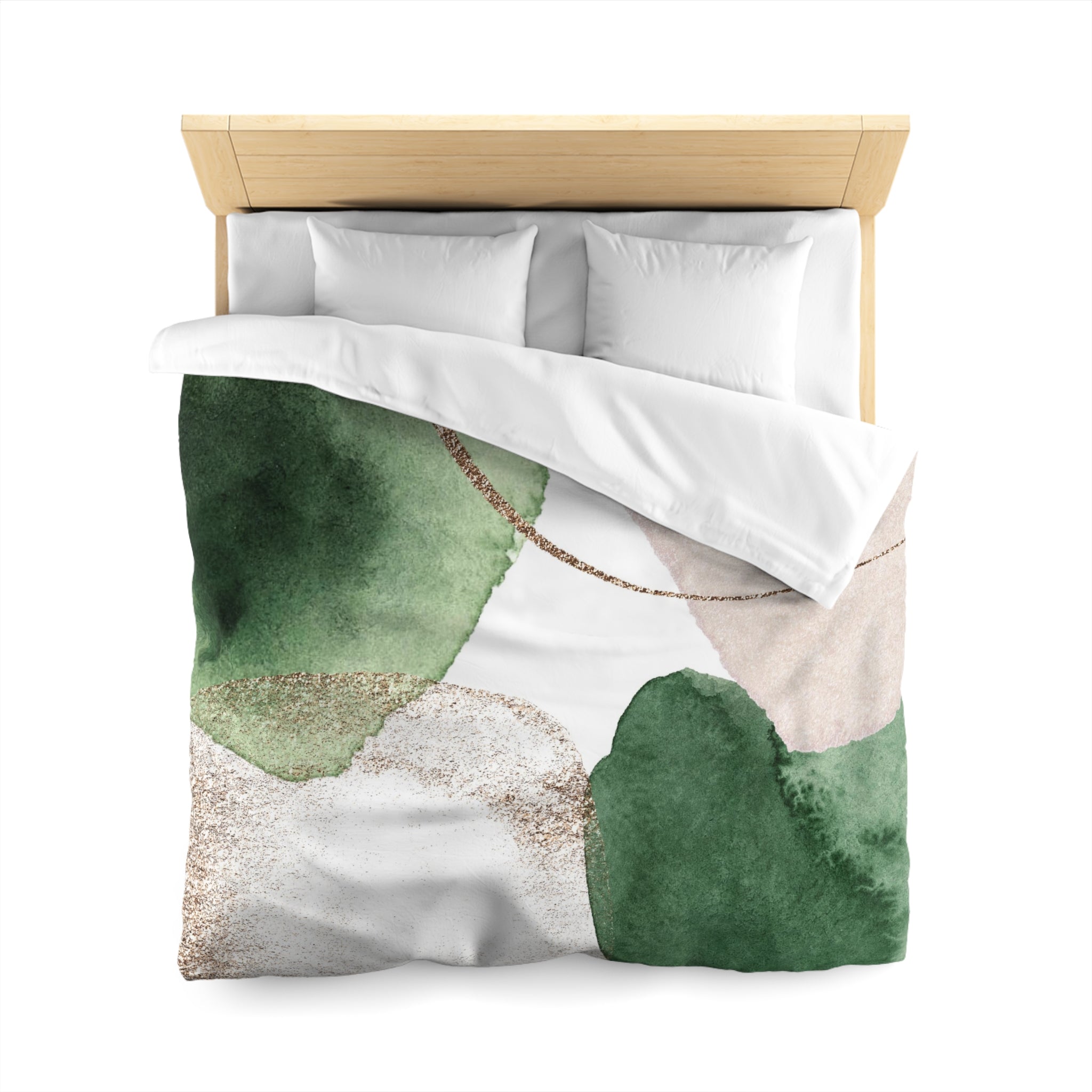 a bed with a green and white watercolor-style comforter and pillows.