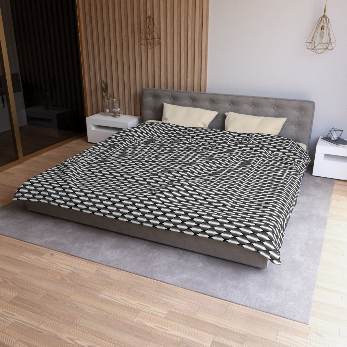 a modern bedroom with a large bed, a gray headboard, and a black and white patterned comforter. The room has a wooden floor and white walls, creating a clean and minimalist aesthetic.