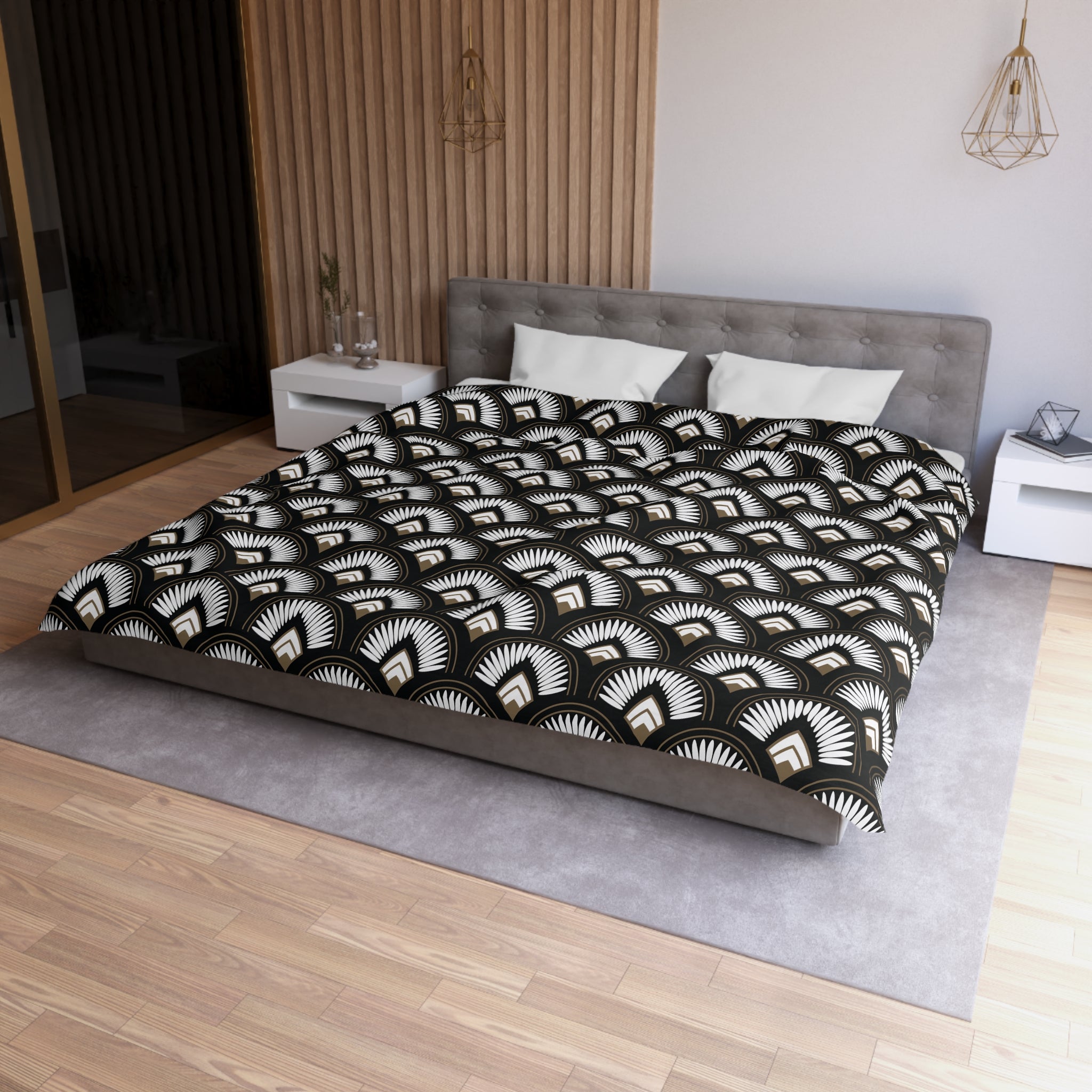 a modern bedroom with a large bed, a gray headboard, and a black and white patterned comforter. The room has a wooden floor and white walls, creating a clean and minimalist aesthetic.
