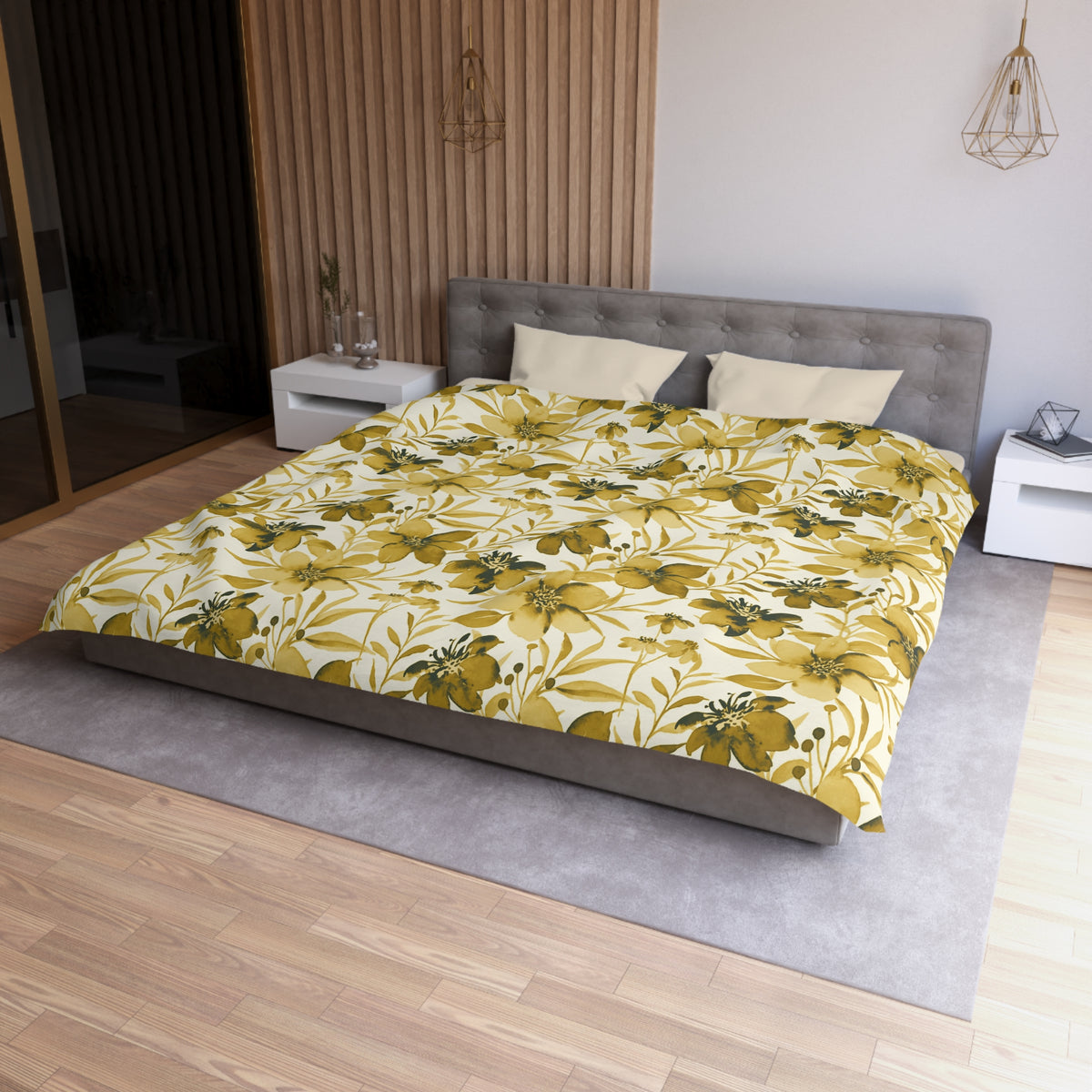 a modern bedroom with a large bed featuring a yellow and green floral comforter. The bed is positioned against a wall with a wooden panel. The room has a gray headboard and a white nightstand on each side of the bed. There is also a pendant light hanging above the bed.