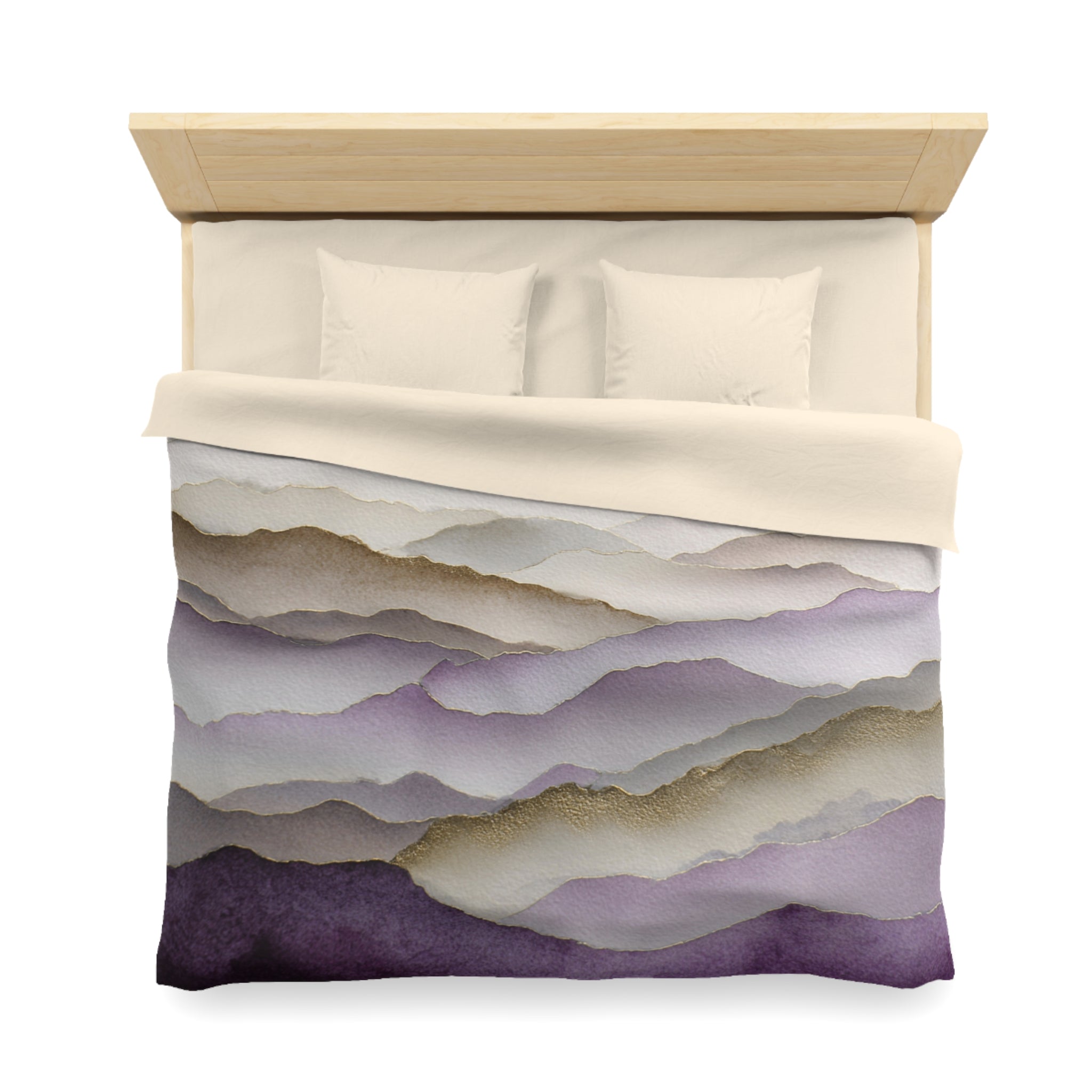 a neatly made bed with a comforter featuring a mountain landscape design in shades of purple and gray.